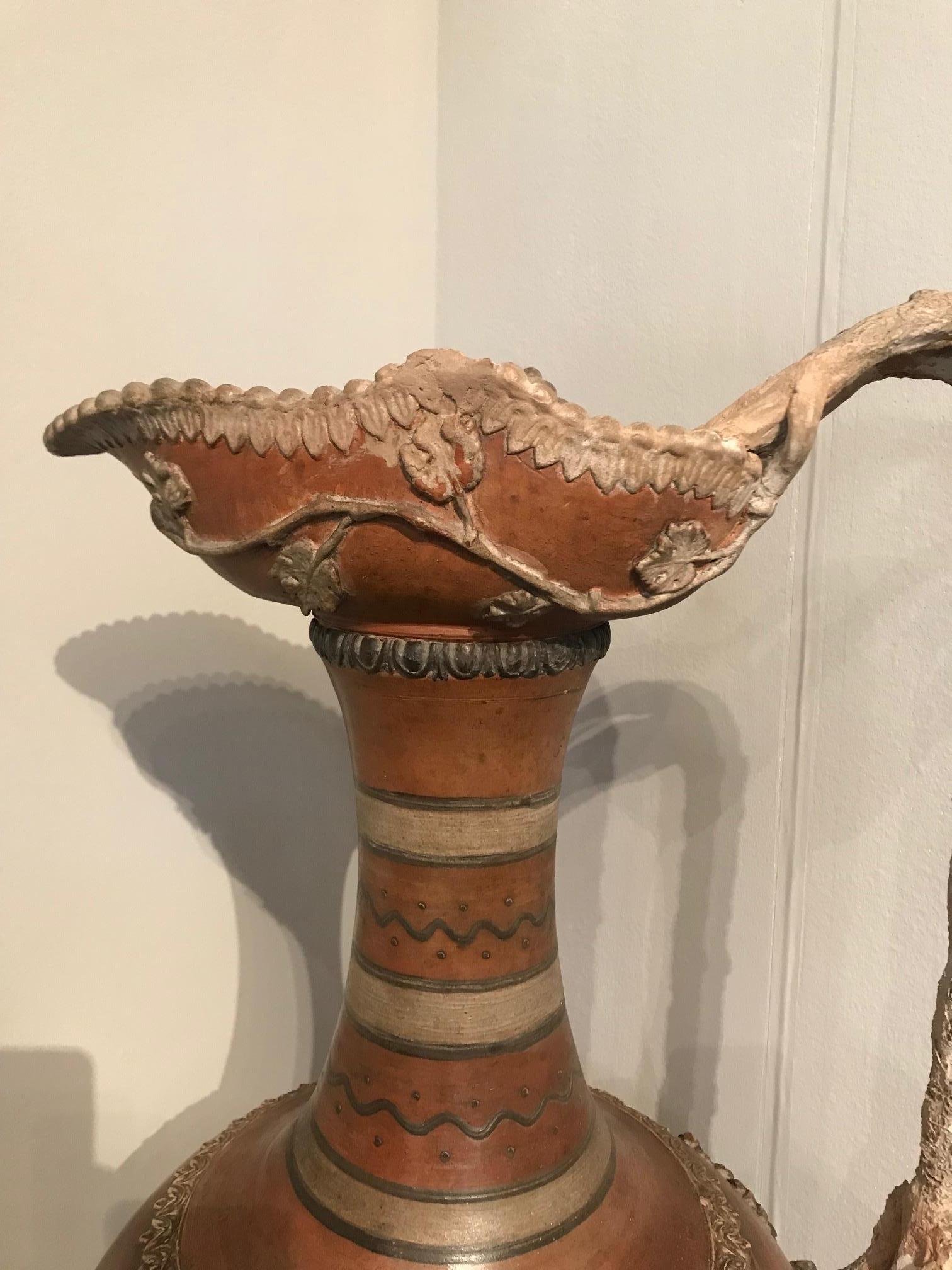 Etruscan style terracotta ewer with wine leaf motifs.