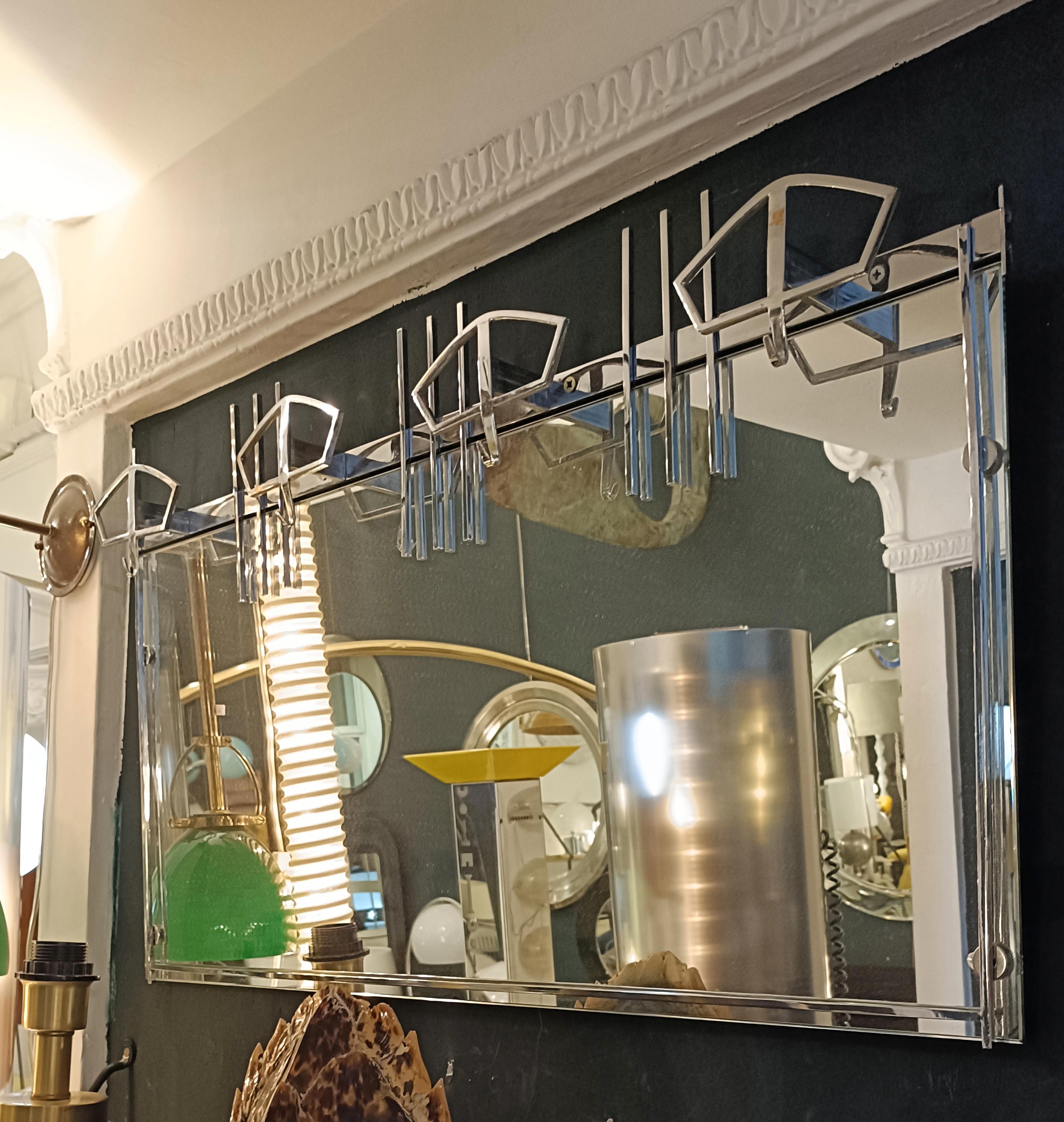 Raro Appendiabiti e specchio da parete interamente in metallo cromato e specchio rettangolare disegnato da Ettore Sottsass per la Ditta Sant Ambrogio e De Berti anni 60.
Da notare un elemento  mancante sul lato Destro.
Ettore Sottsass è stato un