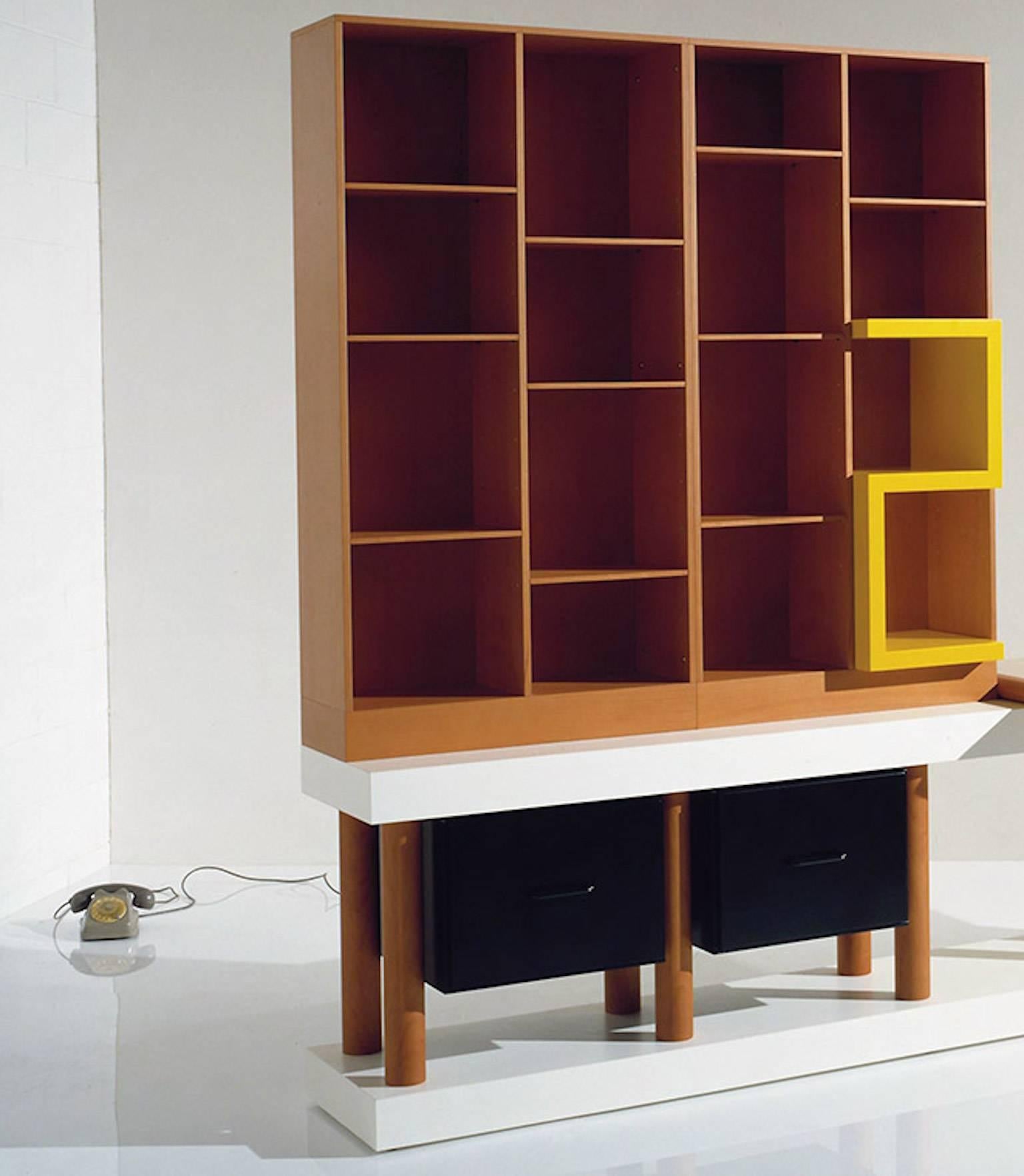 Cabinet consisting of a laminate base with one pear-shaped legs and two black lacquered drawers, upper part with pear-shaped open elements with shelves and yellow lacquered objects and pear-shaped top. Limited edition of 20 copies. Out production.