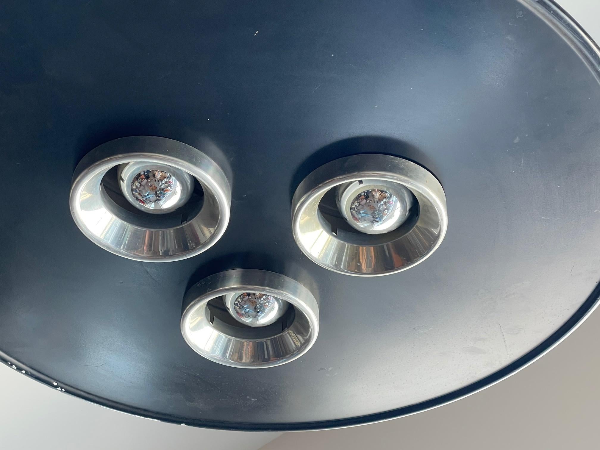 An unusual chandelier from the 1970's by Ettore Sottsass, produced by Stilnovo, Italy. Futuristic design with three aluminum reflectors and matching domes on top.