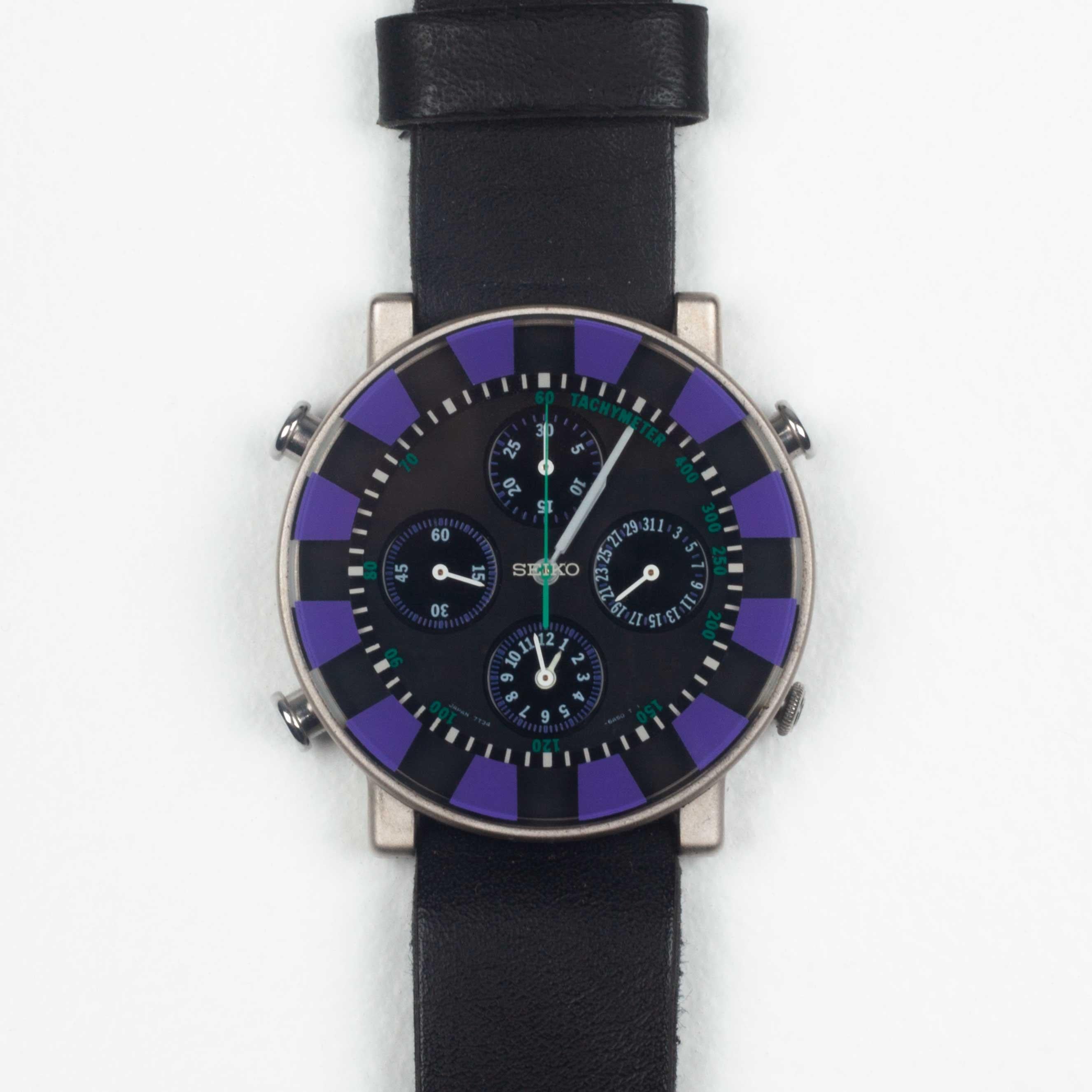 First edition, out-of-production SOTTSASS COLLECTION wrist watches designed by Ettore Sottsass, released in Japan by Seiko in 1992. Purple, black and white face. Teal second hand and tachymeter numbers, white minute and hour hands. A floating effect