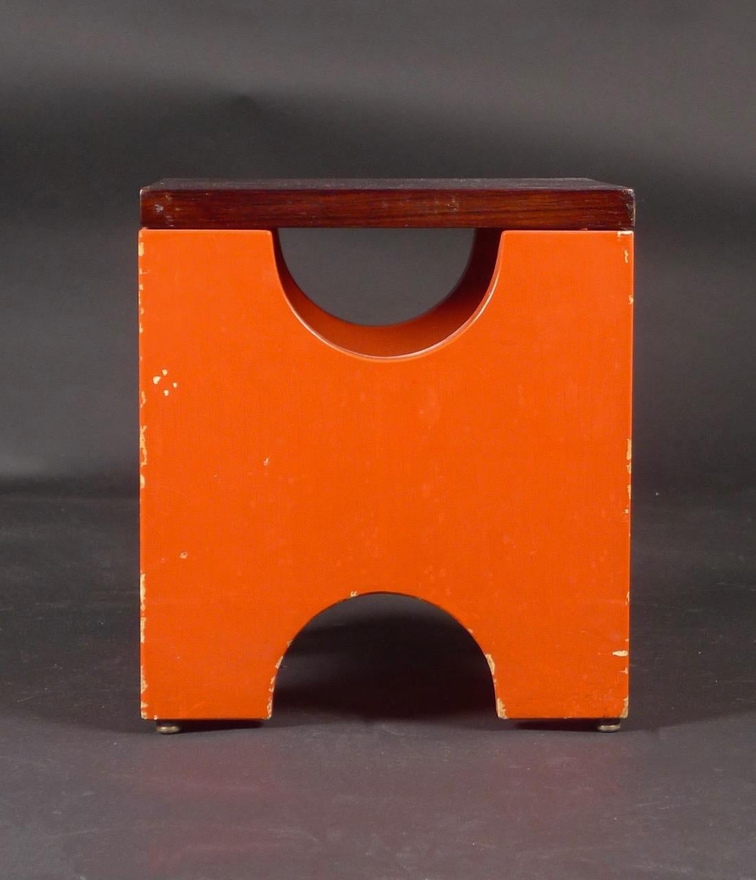 Ettore Sottsass, tabouret Dado, modèle T29, conçu en 1963 et fabriqué par Poltronova, Italie, dans les années 1960.

La base en bois est peinte en rouge brique et le plateau est en noyer.  La base est munie de quatre pieds métalliques à boutons.