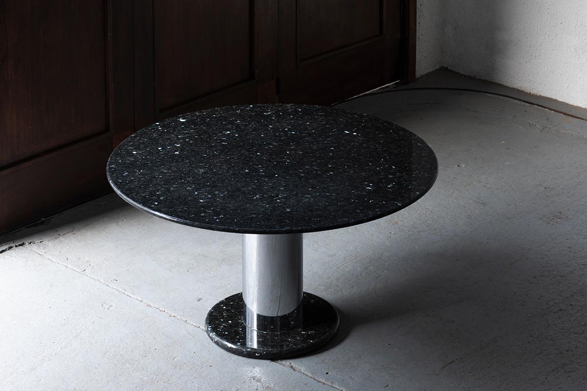 This is the exclusive 'Lotto Rosso' dining table, designed by Ettore Sottsass and produced by Poltronova in Italy around 1980. This solid round table holds an iridescent granite table top on a chrome plated steel base and a dark granite foot. The