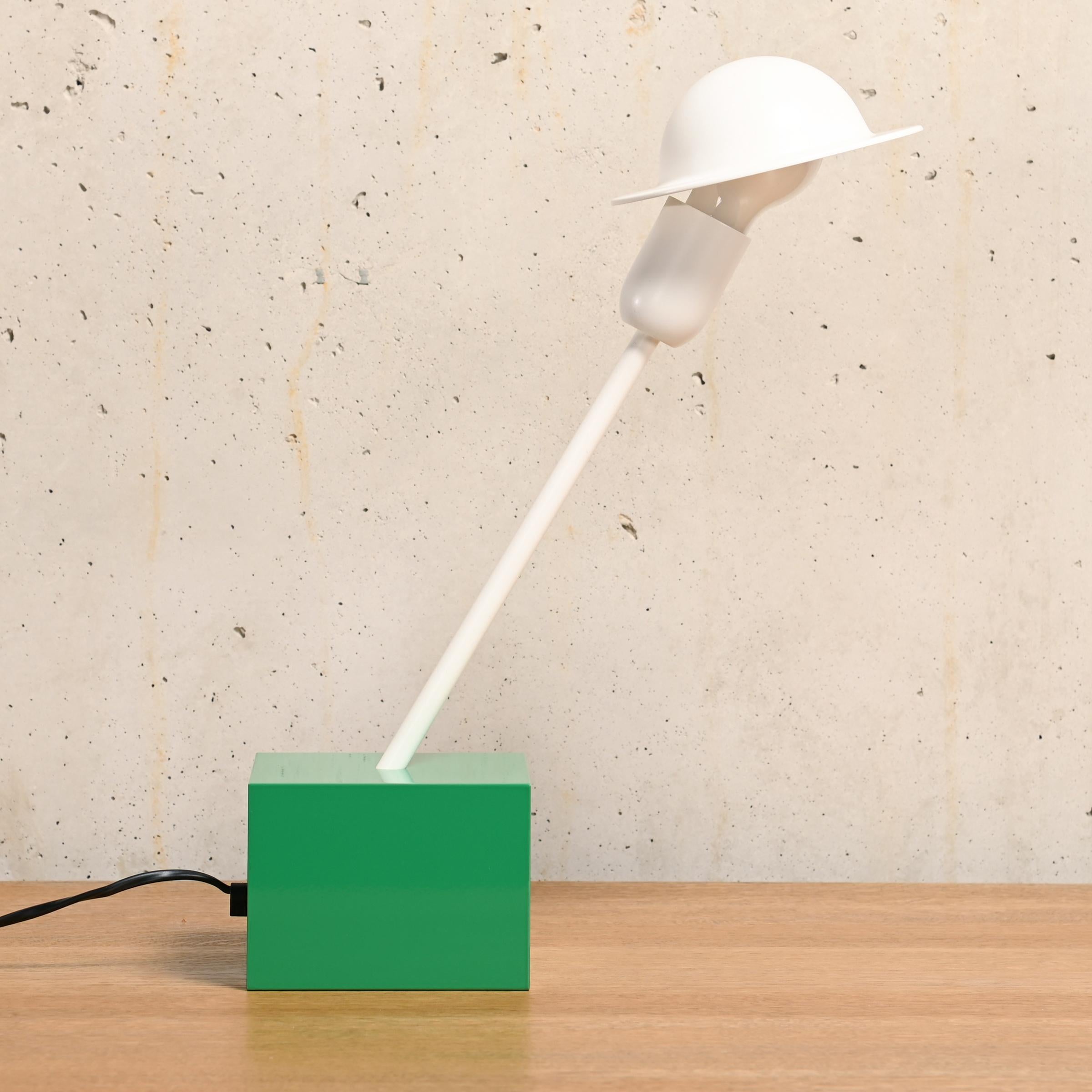 Great and playful 'Don' table lamp designed by Ettore Sottsass for Stilnovo, Italy in 1977. The lamp has a heavy bright green cubic base and a white slanted rod with lamp holder. The lampshade is attached to the lightbulb with a metal clip and can