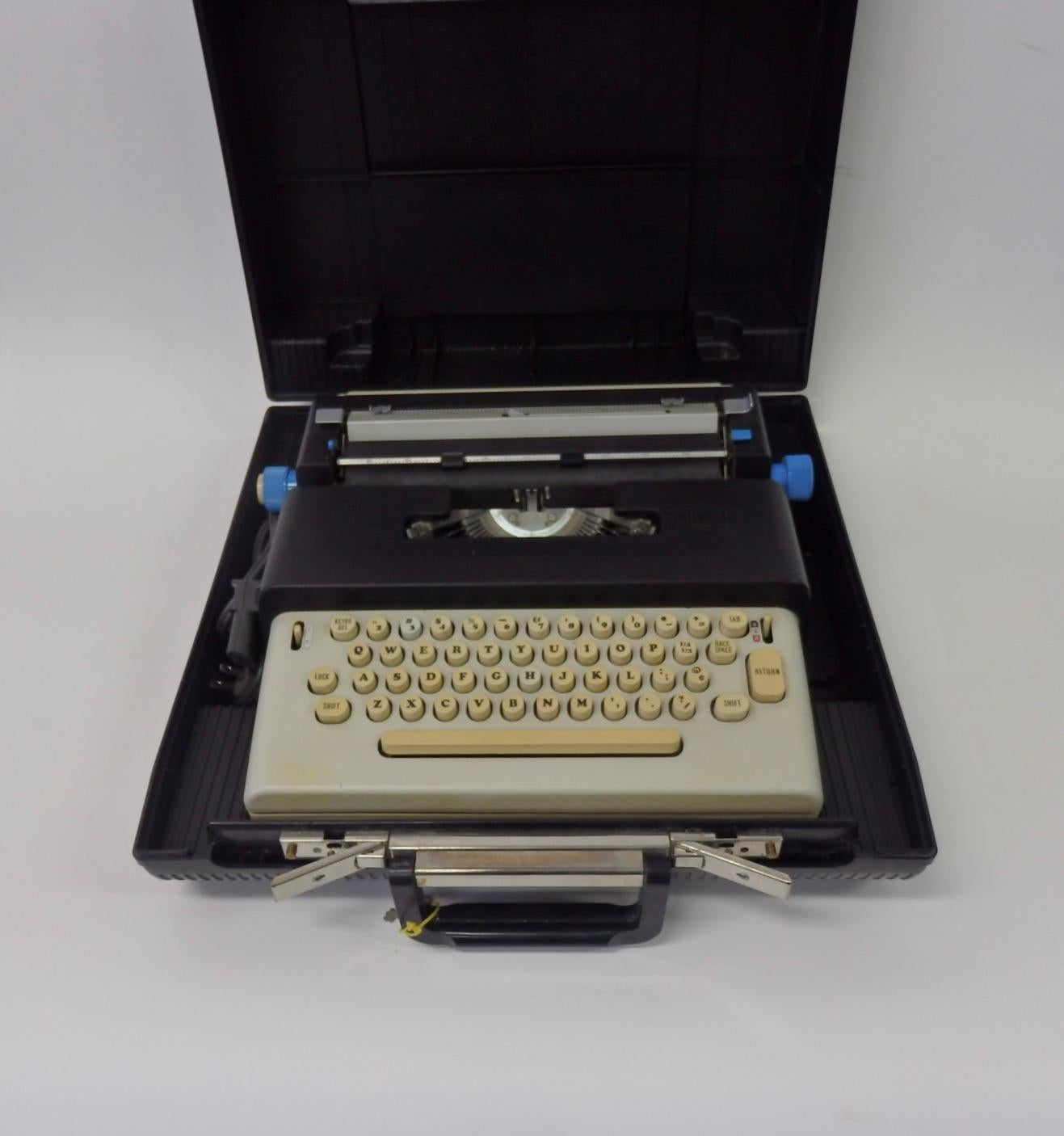 Olivettis first portable electric typewriter. Designed by Ettore Sottssas. Very complete example with carrying case and cord. In excellent condition.
