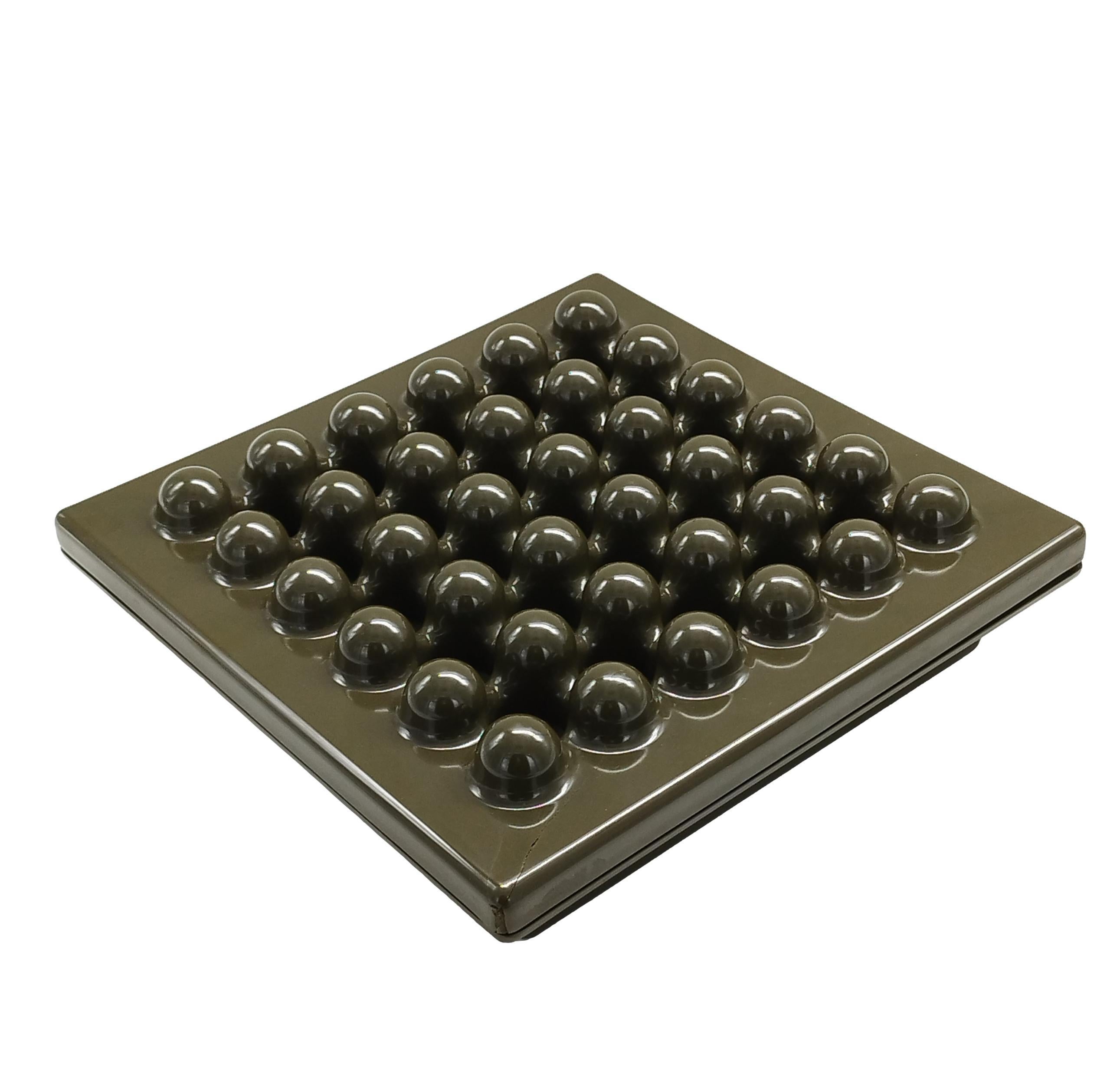 One of the greatest coffee table statement pieces ever created, the Synthesis Ashtray — designed in the 1970s by Ettore Sottsass for Olivetti — features a grid of raised bumps that alternate with holes to catch ashes.
Crack in one corner as photo.