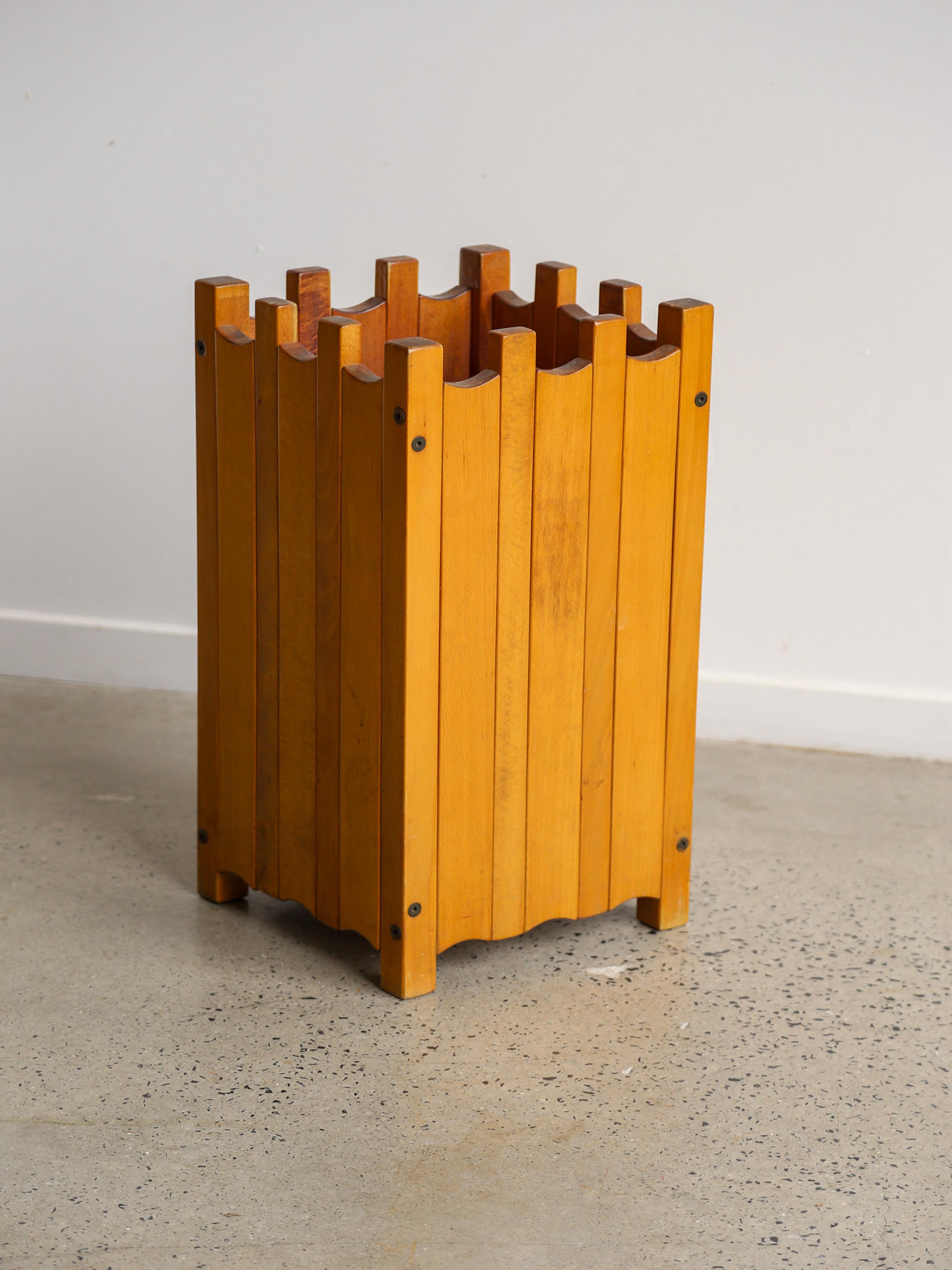 Wooden umbrella stand by the famous Ettore Sottsass 

Ettore Sottsass (1917–2007) was an Italian architect and designer, best known for founding the Memphis Group in the 1980s, which had a profound impact on postmodern design. Sottsass had a long