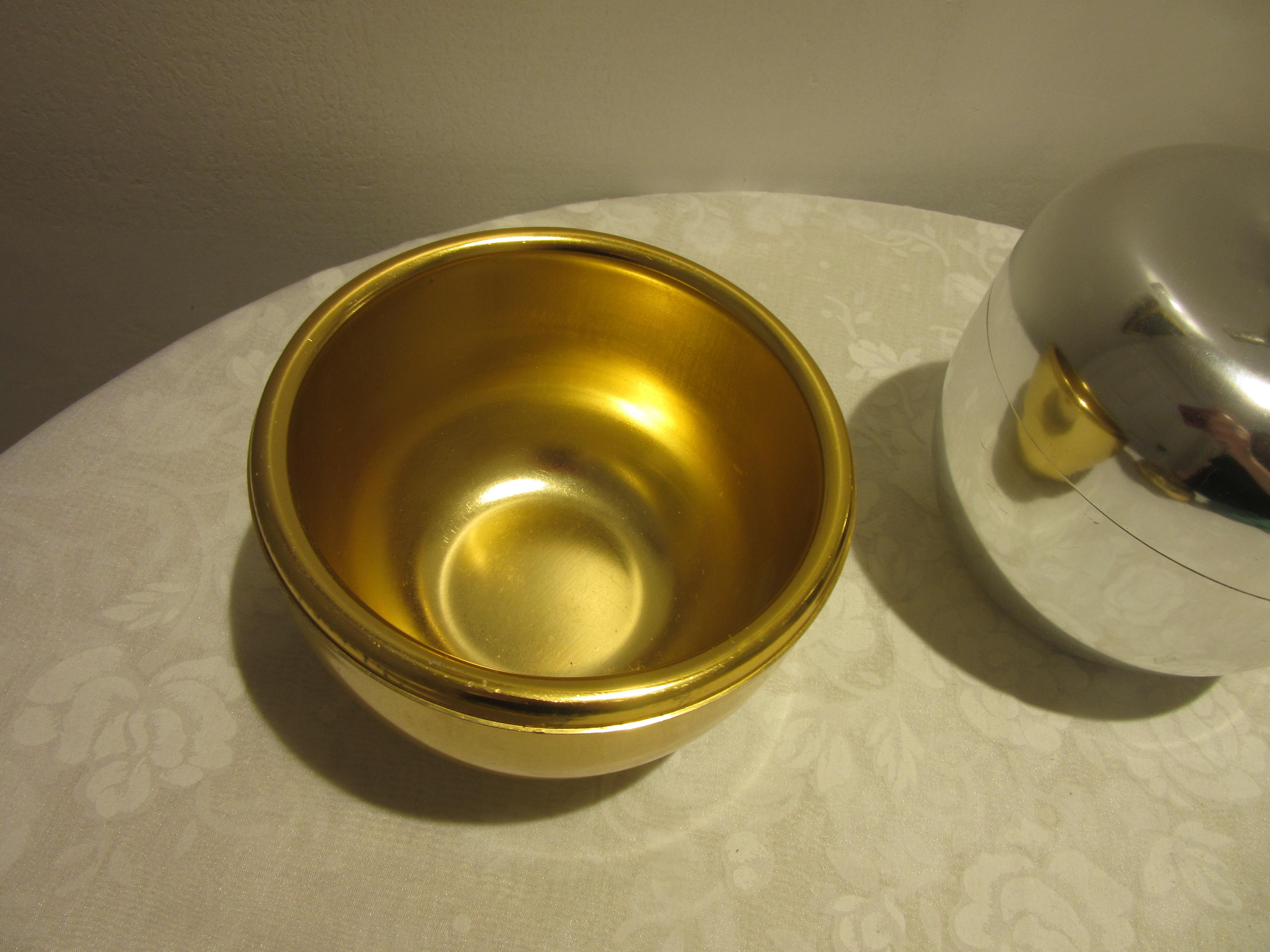 Italian Mid-Century Modern pair of aluminum ice buckets; one silver and the other gold, designed by Ettore Sottsass for Rinnovel. Both pieces are in the shape of an apple and are entitled “Mela”. The gold-tone bucket has the same color aluminum