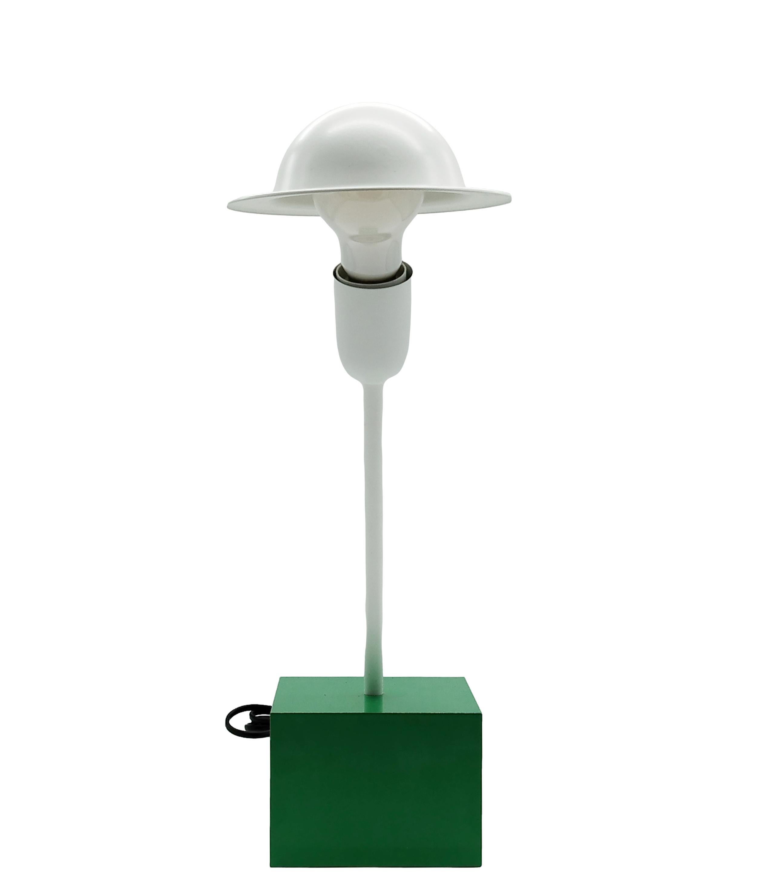 A Don table lamp designed by Ettore Sottsass in 1977. The lamp was manufactured by Stilnovo, Italy, and has a manufacturer’s label.
Consisting of a heavy cubical emerald green base with a white slanted rod and adjustable 'bowler hat' shade.
Ettore