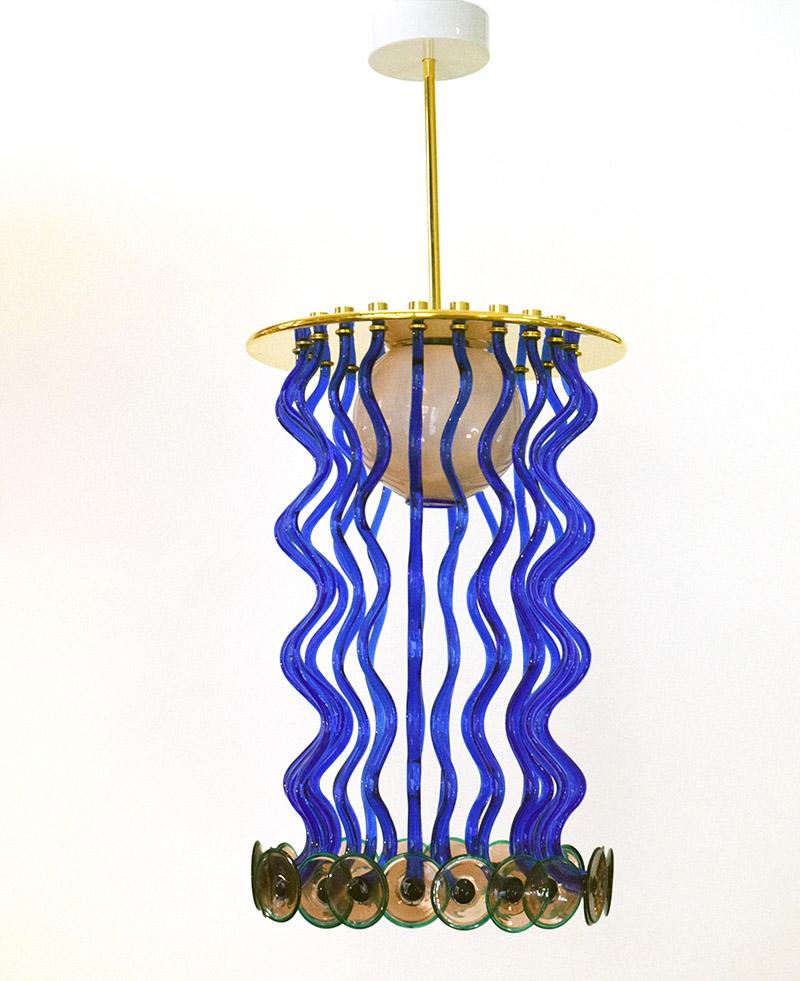 Ettore Sottsass for Venini rare ‘Formosa’ chandelier, 1989.
Structure and plate in chromed brass, central diffuser in blown incamiciato glass with blue profile, blue glass hanging ‘tentacles’ with disk terminals in amethyst color with green rim,