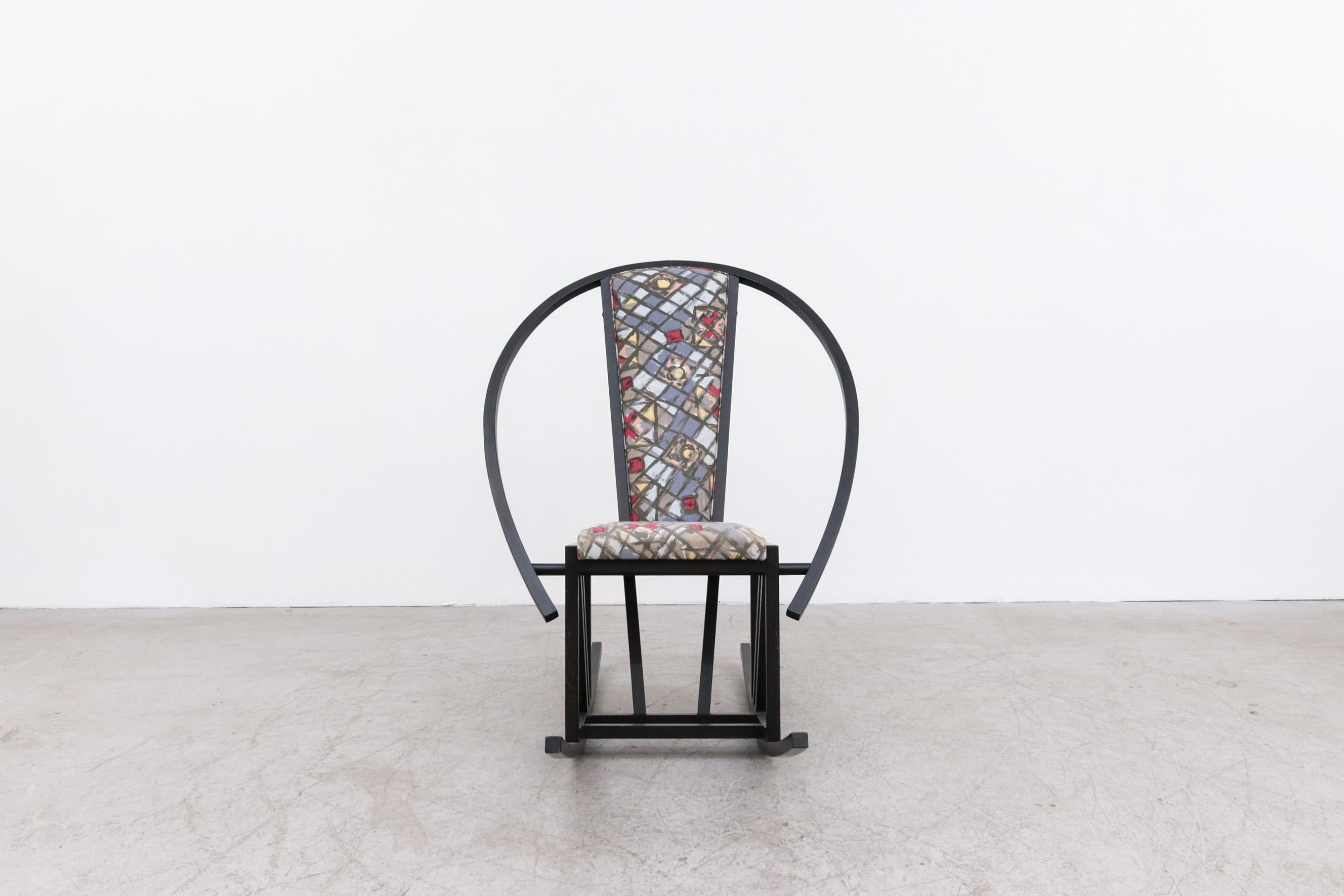 Amusant fauteuil à bascule de style Memphis inspiré par Ettore Sottsass avec un cadre en bois noir ébonisé courbé. Cette chaise est également dotée d'un revêtement imprimé graphique de style Memphis. Mesures : La largeur du siège est de 15