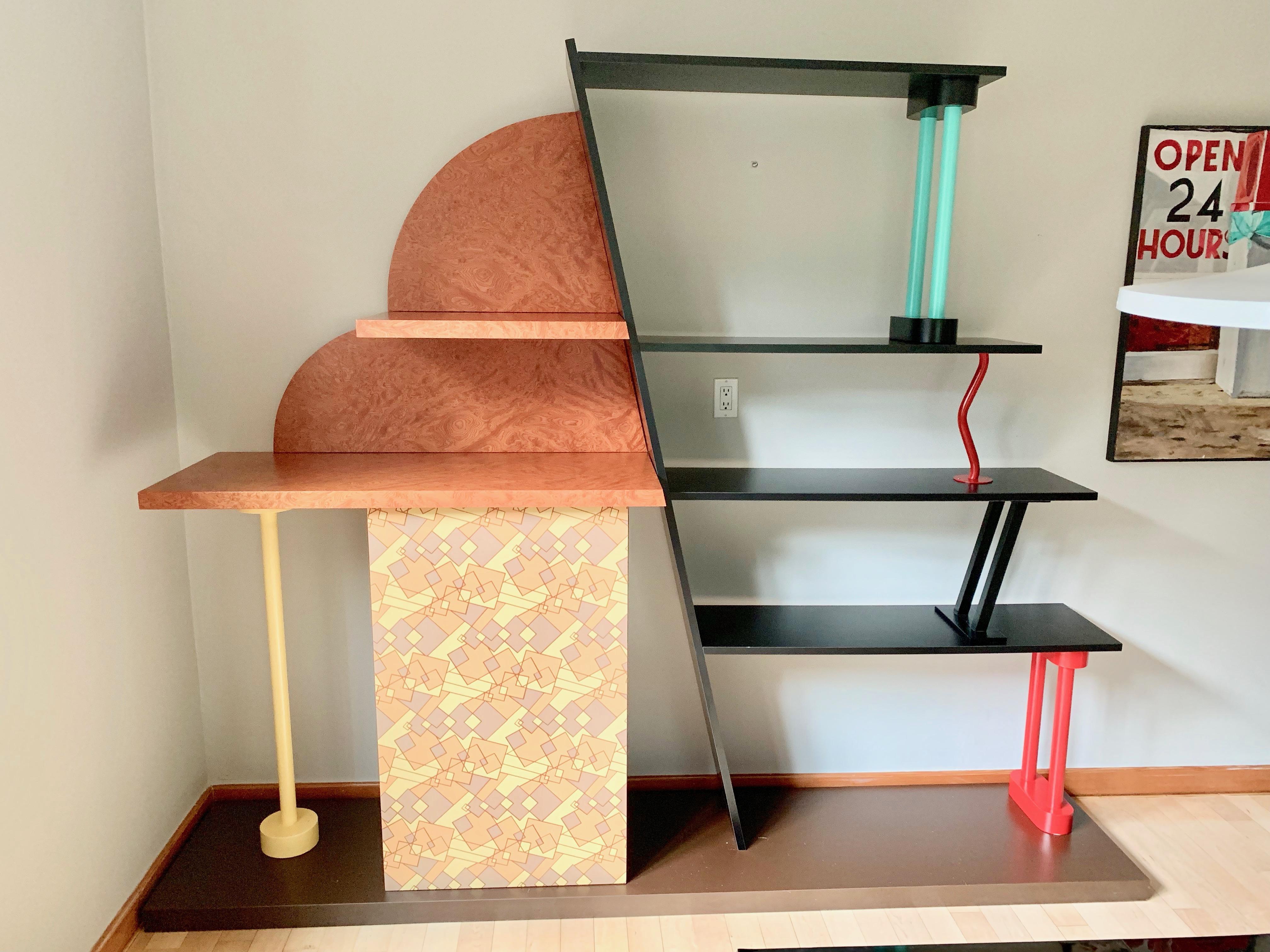 Terrific example of Memphis furniture by Ettore Sottsass. Made in 1982 for Memphis Milano in Italy. Laminated wood zig-zag shelves with enameled steel rods in varying colors. Large cupboard with geometric patterns. Fantastic sculptural shelf