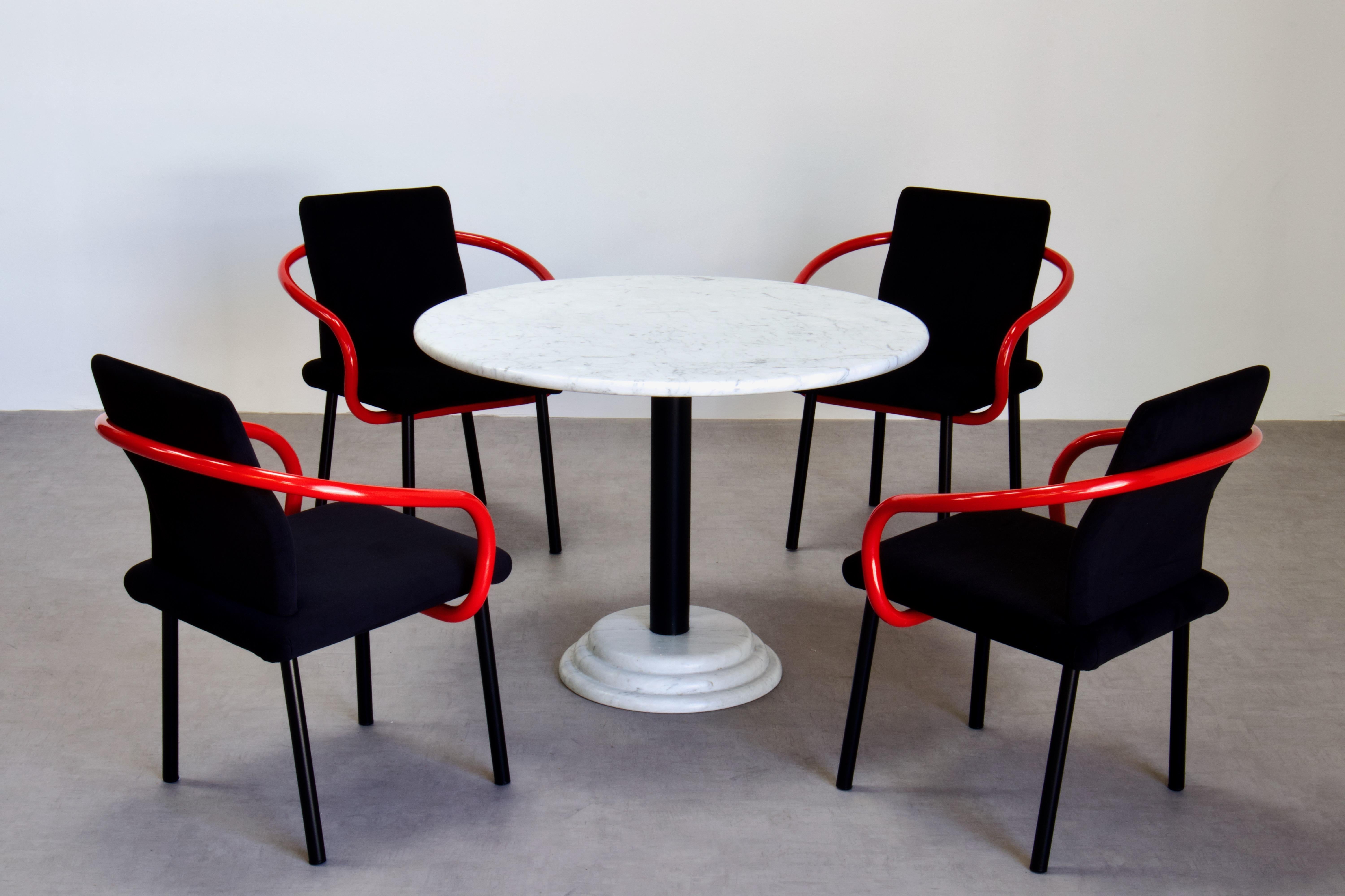 Ikone der Memphis Milano-Bewegung. Ein Satz von vier Mandarin-Stühlen von Ettore Sottsass für Knoll. Schwarze Alcantara-Polsterung. Die Arme sind rot lackiert. Außerdem ein runder Esstisch mit Sockel aus Carrara-Marmor, der Ettore Sottsass