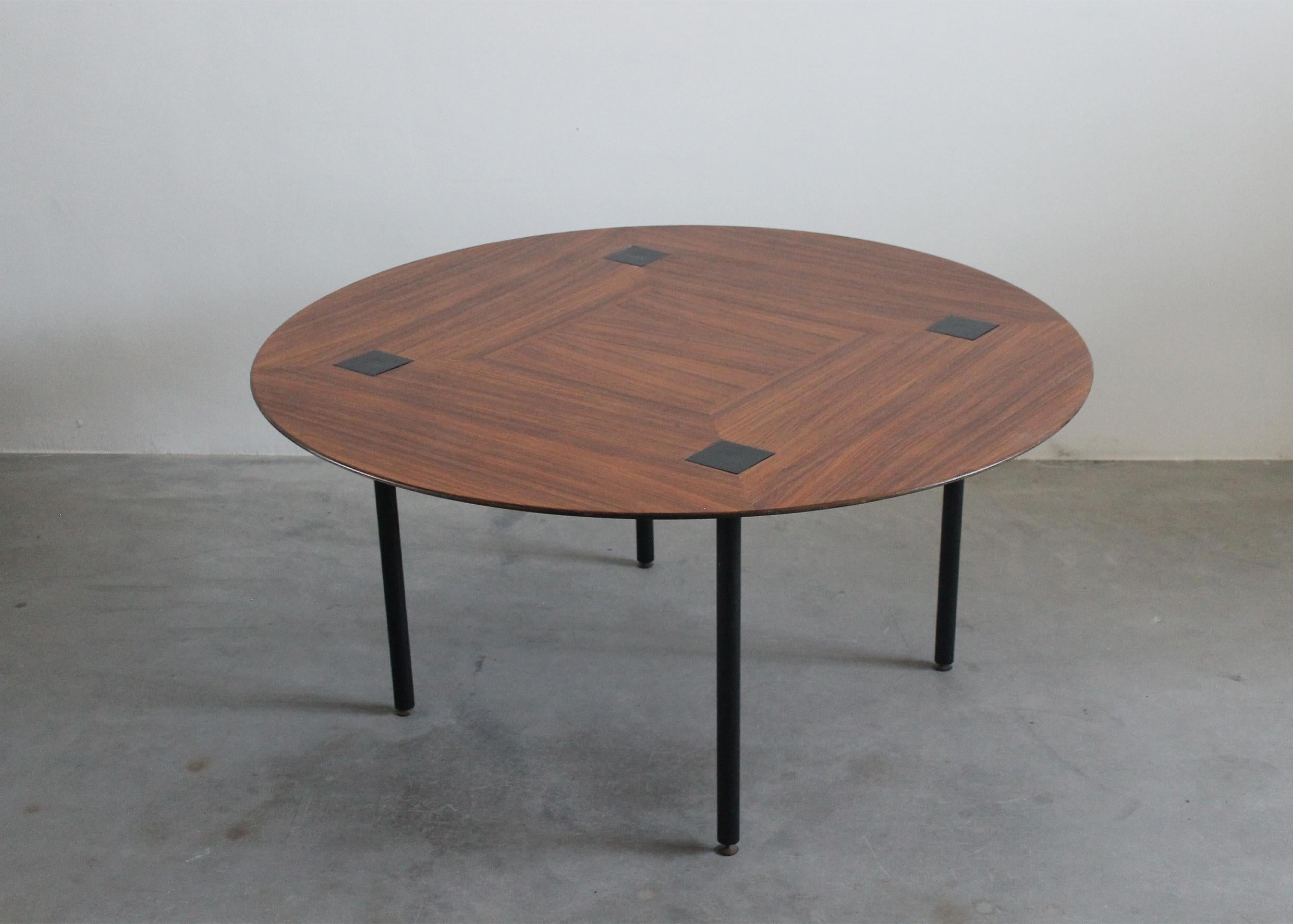 Round dining table or living room table with four legs in black lacquered metal, table top in wood and brass details. 
The peculiar tabletop presents a beautiful decoration due to the wood grains, and it also presents four black lacquered metal