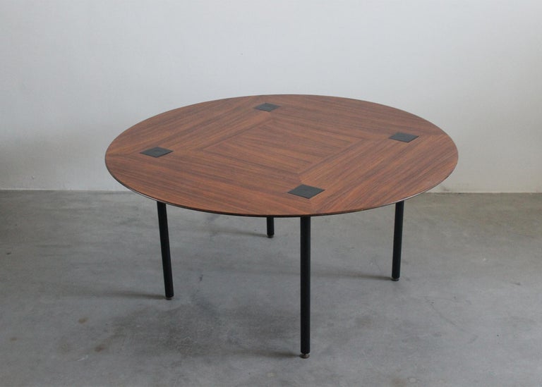 Round dining table or living room table with four legs in black lacquered metal, table top in wood and brass details. 
The peculiar tabletop presents a beautiful decoration due to the wood grains, and it also presents four black lacquered metal