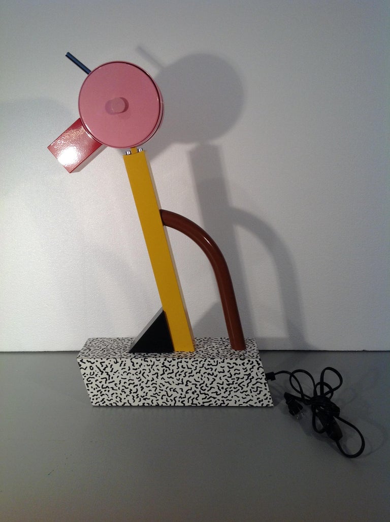 The ultimate Sottsass table light!! 

Anthropomorphic (looks like a parrot) as the head (w/ lamp) swivels up and down. 

Designed for the inaugural 1981 MEMPHIS exhibition, this lamp harkens to the movement's purest moments. The