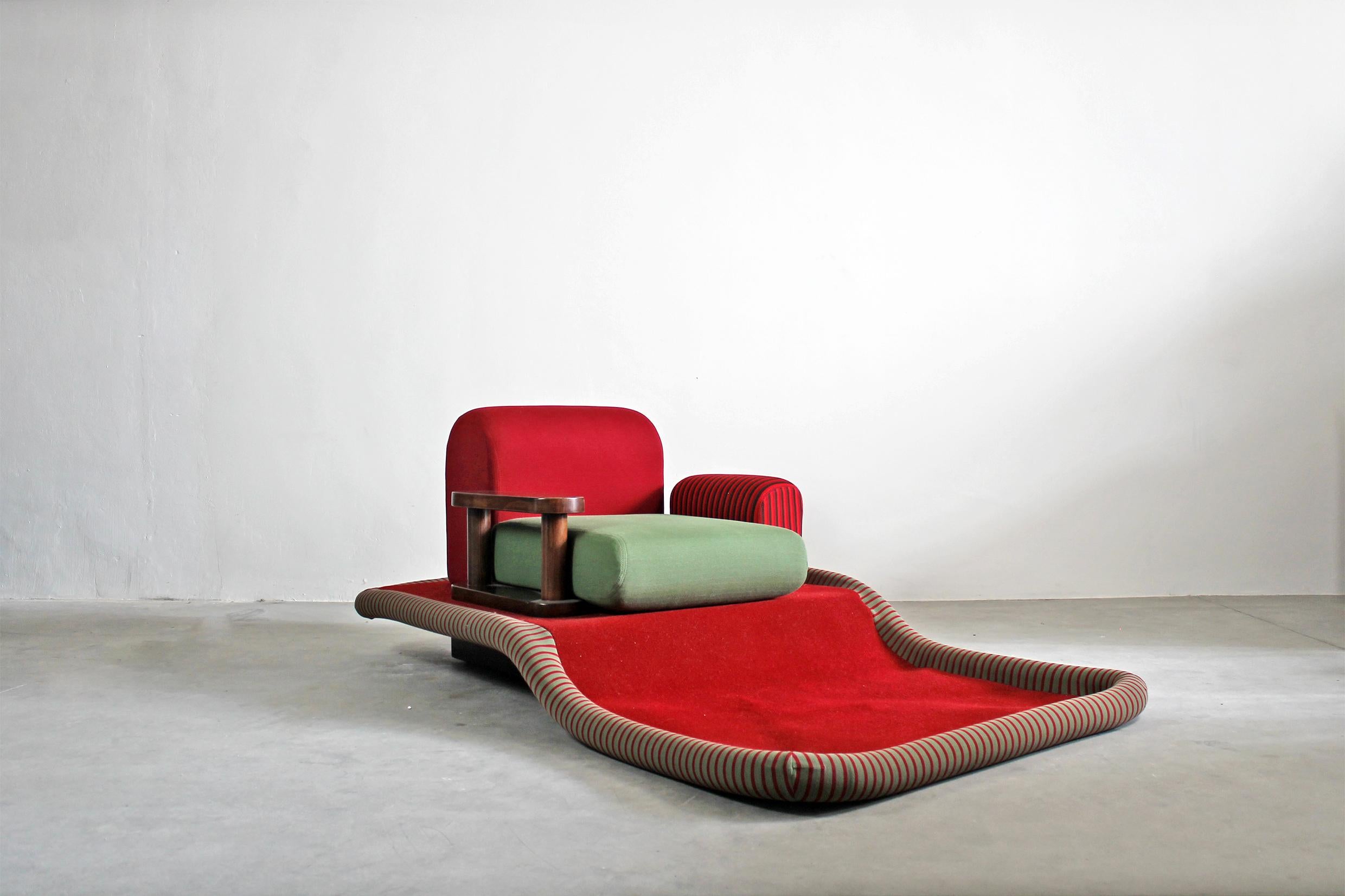 The Flying Carpet or Tappeto Volante armchair is an iconic seat with a base and an armrest in beech wood, the seat, and the back are made with polyurethane foam padding with multicolored fabric, velvet, and carpeting.
It was designed by Ettore