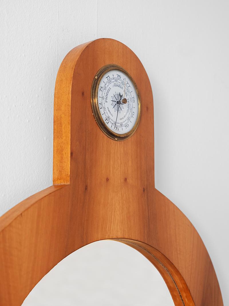 Armadio da parete Tempus in legno e legno laccato bianco, con un pannello frontale a forma di porta, uno specchio e un barometro, disegnato da Ettore Sottsass e prodotto da Poltronova negli anni Sessanta. 

