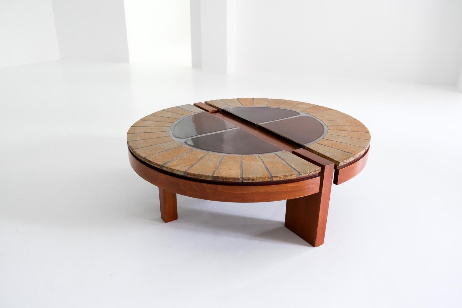 a beautiful detailed, slightly oval coffee table. the top with the handcrafted ceramic tiles rests on an unconventionally constructed wooden frame. this unique piece is signed by the designer in one of the outer tiles.  
 
please note that this
