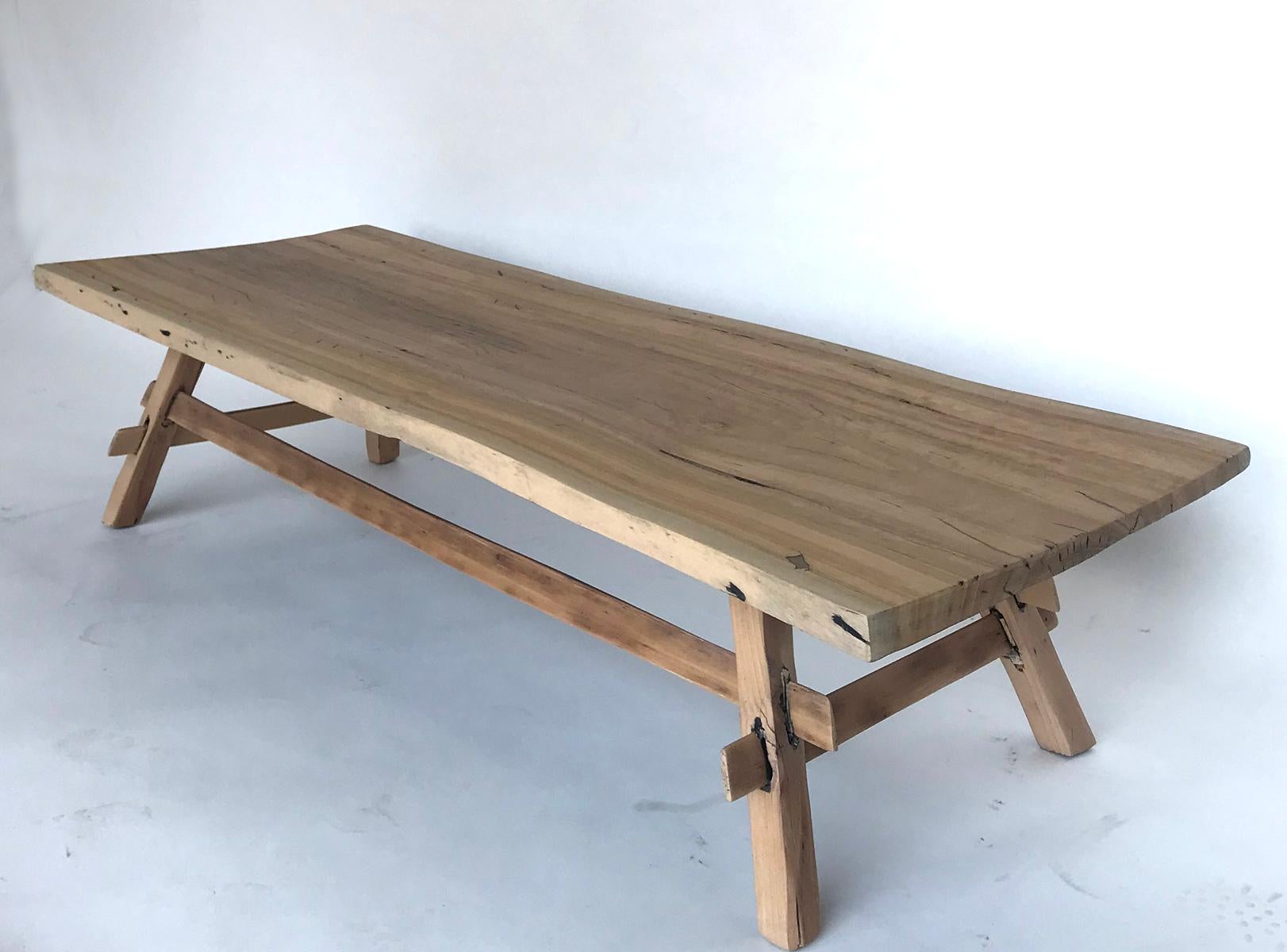 Eucalyptus wood top coffee table with stretcher base. Slightly undulating one wide board top. Natural clear matte finish. Sturdy, functional and simplistic.