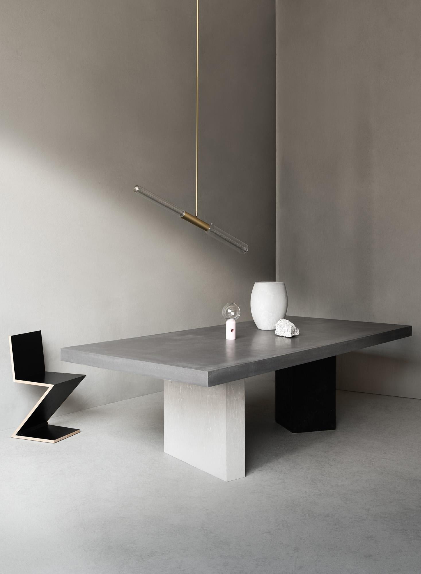 This table embodies the brand philosophy of discovering physical and stylistic lightness in a material that is traditionally regarded as heavy and rough. Fashioned of high-performance concrete, the rectangular top is supported by two asymmetric legs