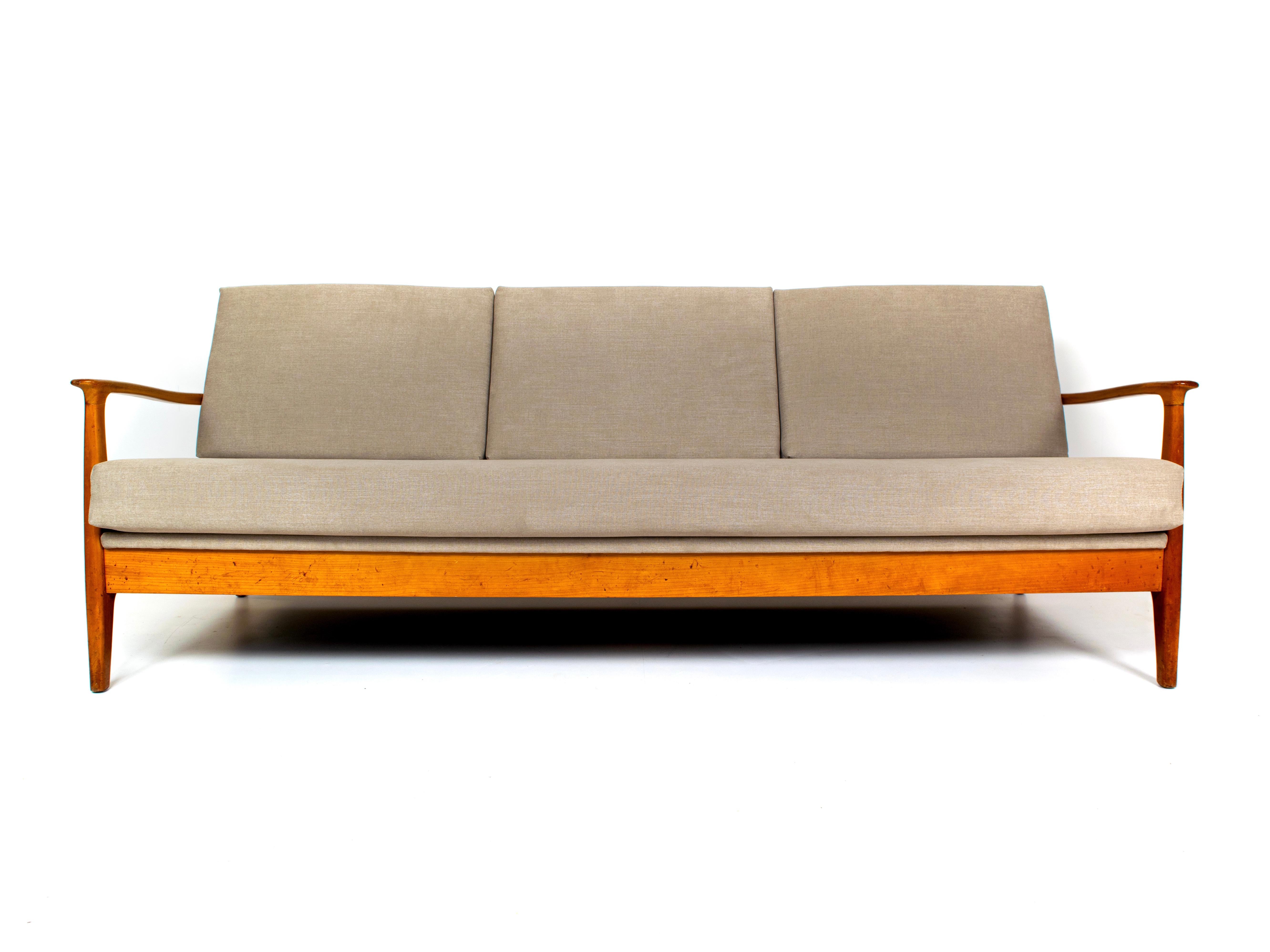 Extraordinary cherrywood sofa and daybed by Eugen Schmidt for Soloform, Germany, 1960s. This sofa fits three people and can be easily extended into a daybed. The entire sofa has been re-upholstered, also the complete back and the mechanism for the