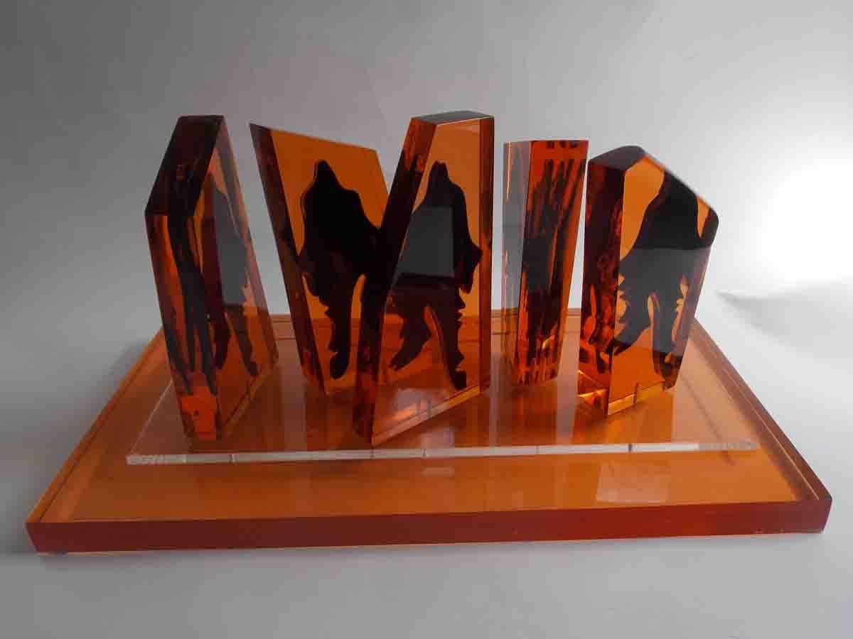 A group of amber monoliths with encased abstract figures.
Pieces peg into a clear sheet of acrylic that sits on top of a thick amber slab.
Signed and dated by the artist.
 