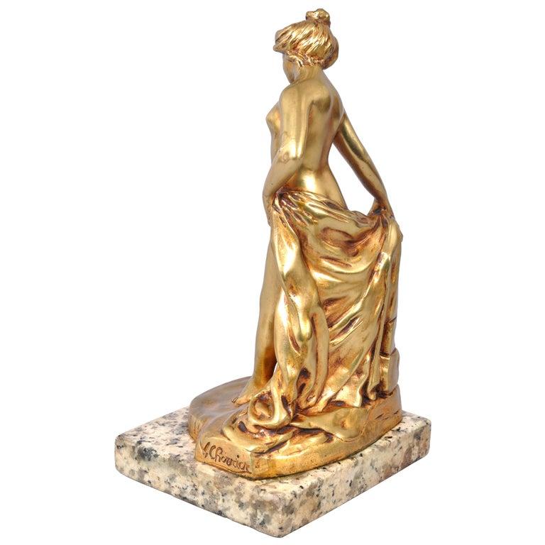 Buena escultura antigua francesa Art Nouveau de bronce dorado de una figura femenina desnuda de una bañista, obra del escultor francés Eugene Victor Cherrier (1872-1943), hacia 1895.
El bronce representa a una bella joven desnudándose tras un muro