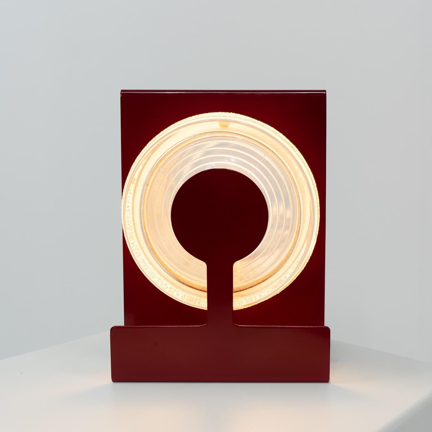 Table lamp named “Yoyo”, consisting of a red coated metal structure with two round glass inserts:

This lamp originates from the 1970s and was produced in Italy. The design is attributed to Eugenio Gentili Tedeschi and produced by Fontana Arte.