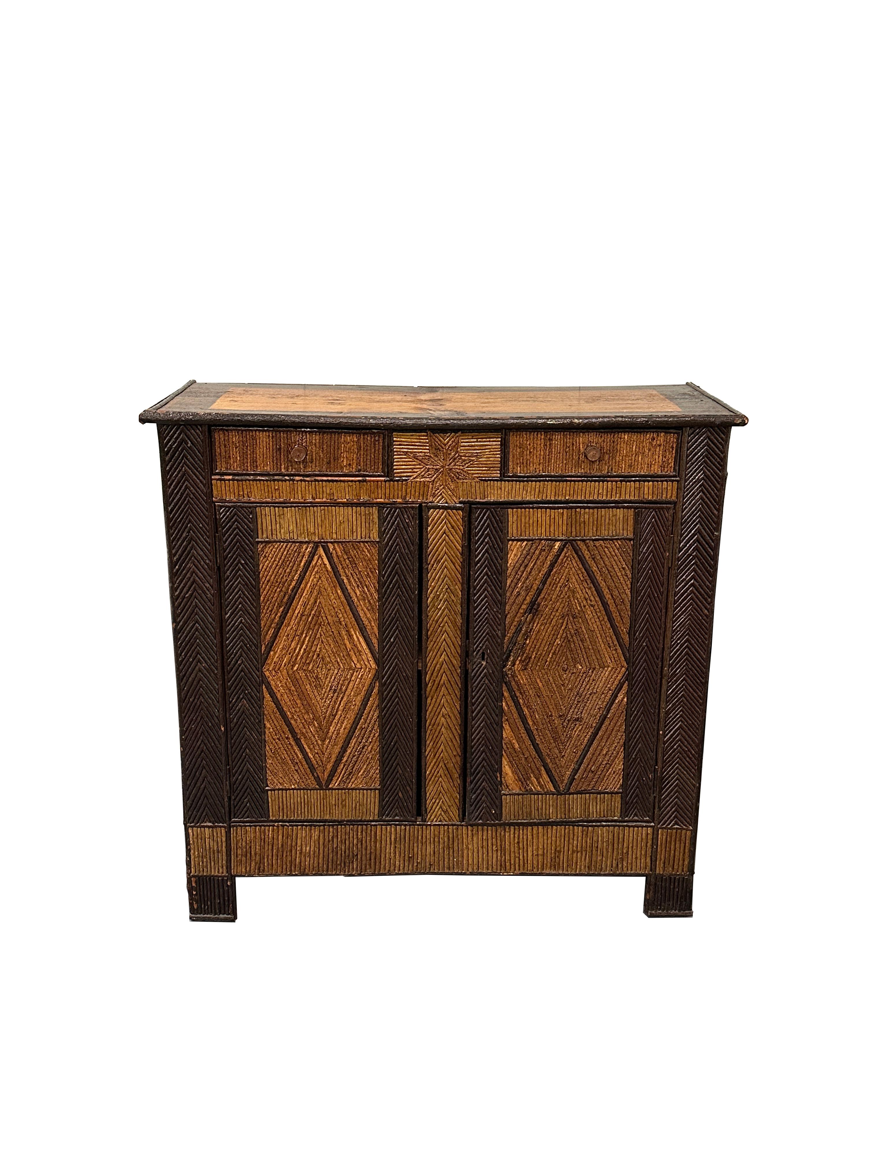 A transitional piece with character and sophistication. Very good condition. Slight ware commensurate with age. The hazel wood is both stained and varnished in two different tones. The filets of wood are assembled into a pattern on the face of the