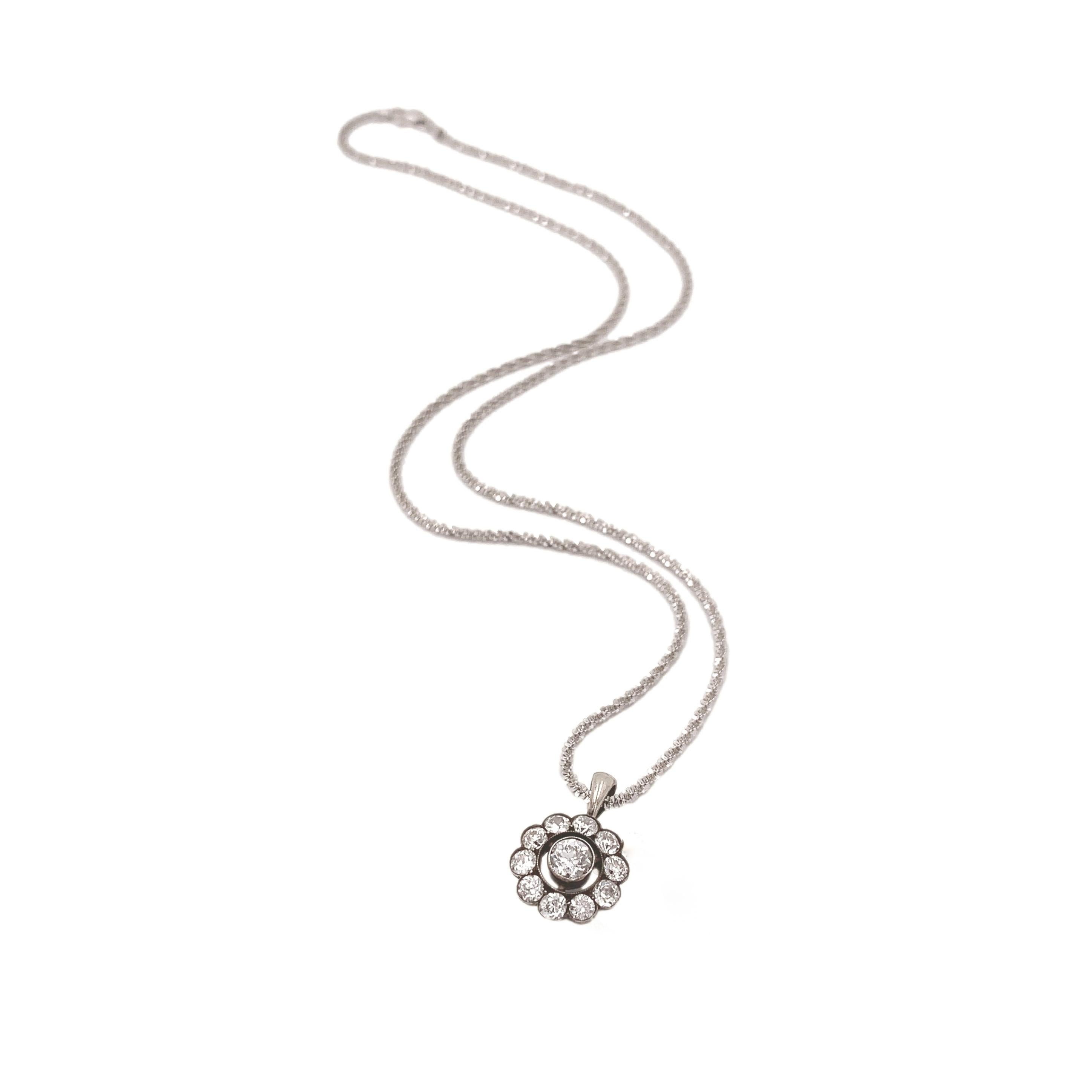 Pendente europeo in argento e 14 carati con una rosetta di diamanti incastonati in una parte superiore in argento su una catena in oro bianco 14 carati. Ci sono 11 diamanti a taglio europeo per un peso totale di circa 1,24 carati. Il diamante