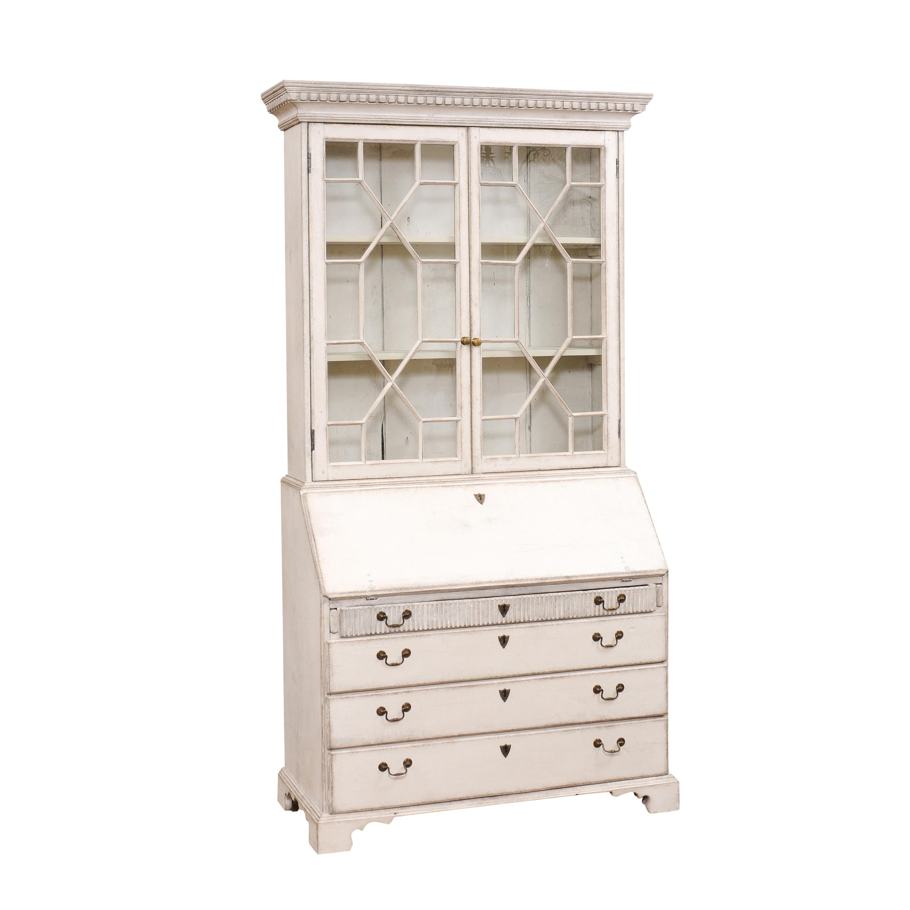 A European painted wood tall two-part secretary circa 1790 with glass doors, carved dentil molding, slant-front desk and four graduating drawers. Enhance your home decor with this exquisite European painted wood tall two-part secretary from the late
