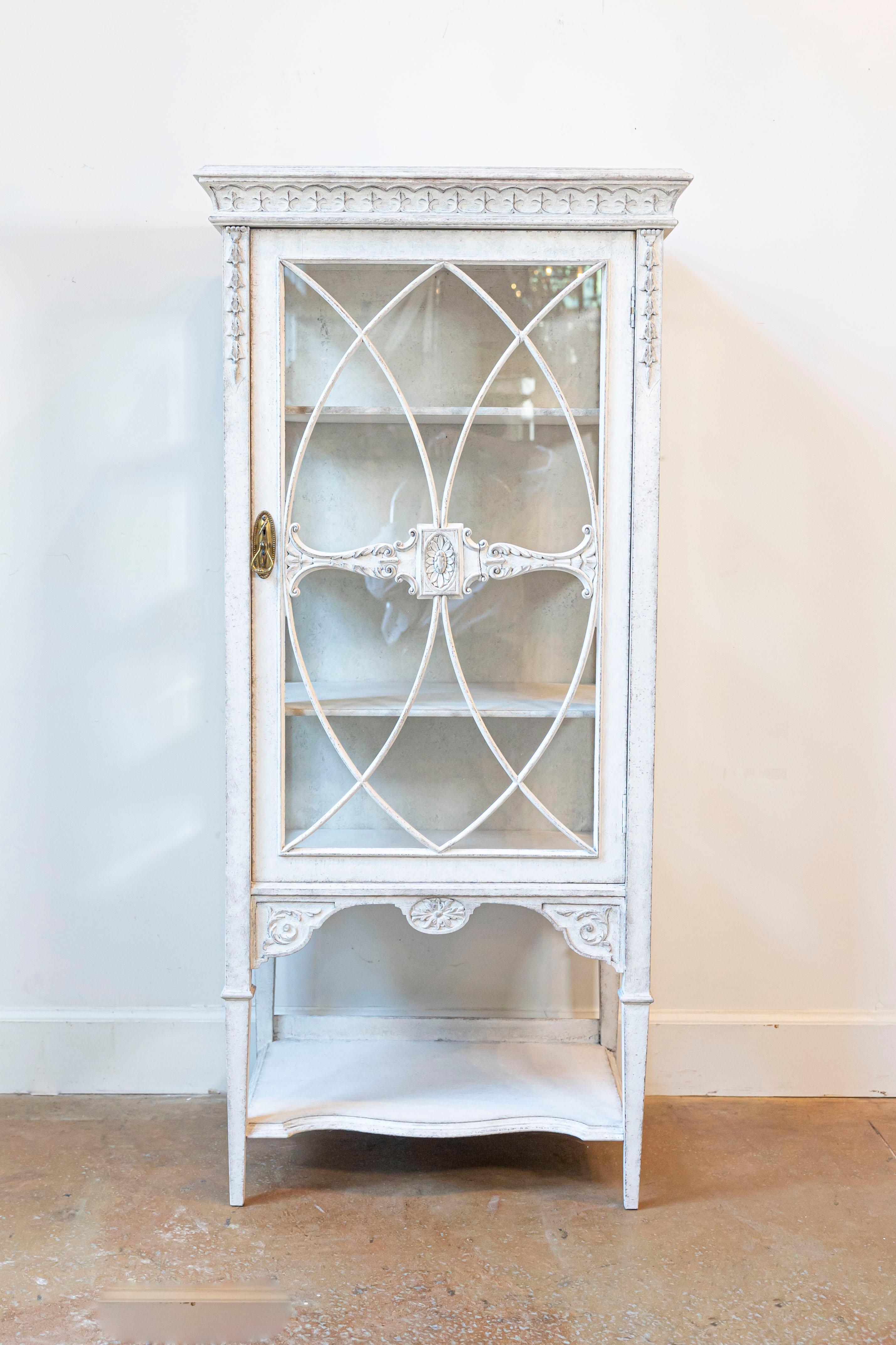 Vitrina europea de madera pintada de finales del siglo XIX, con decoración ricamente tallada, puertas de cristal y estante inferior. Creado en el continente durante la última década del siglo XIX, este elegante mueble vitrina presenta una cornisa