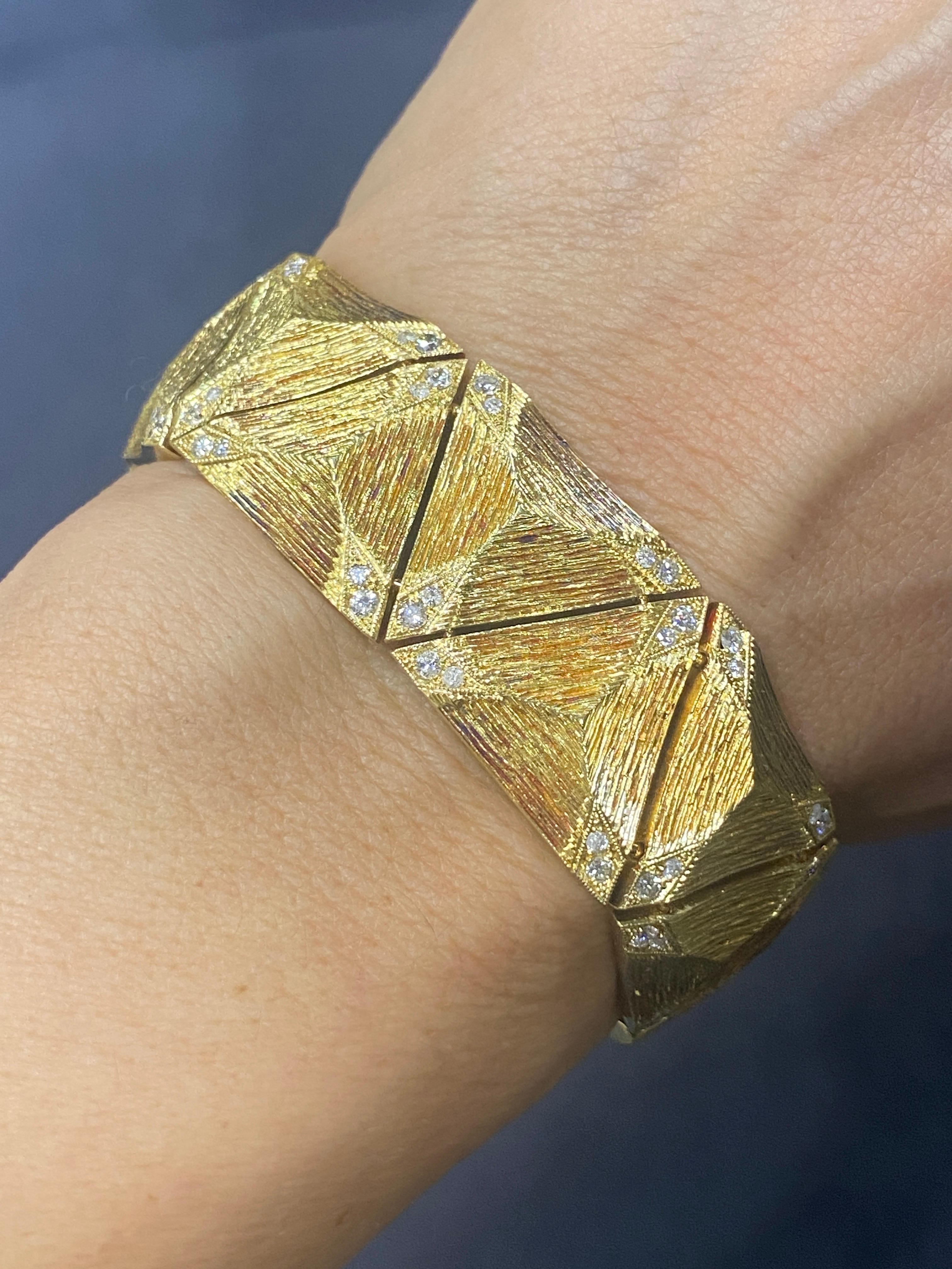 This remarkable 1970s 18k gold bracelet is completely hand made and hand engraved. The corners of each triangular piece is adorned with small diamonds which accentuate the overall sparkle of the bracelet. Although a hefty piece, it lays comfortably