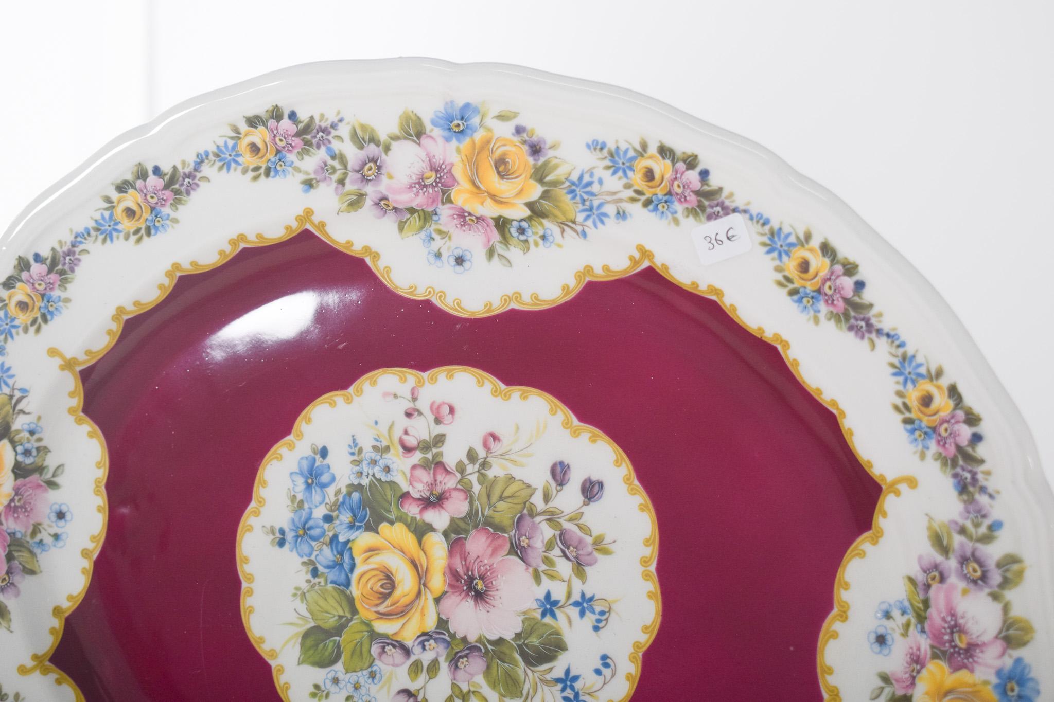Alfa Italian ceramic oval platter. Polychrome decoration with a deep red central background surrounded by a delicate floral pattern. The edges are decorated with flowers in shades of yellow, blue, pink and violet, harmoniously distributed on a white