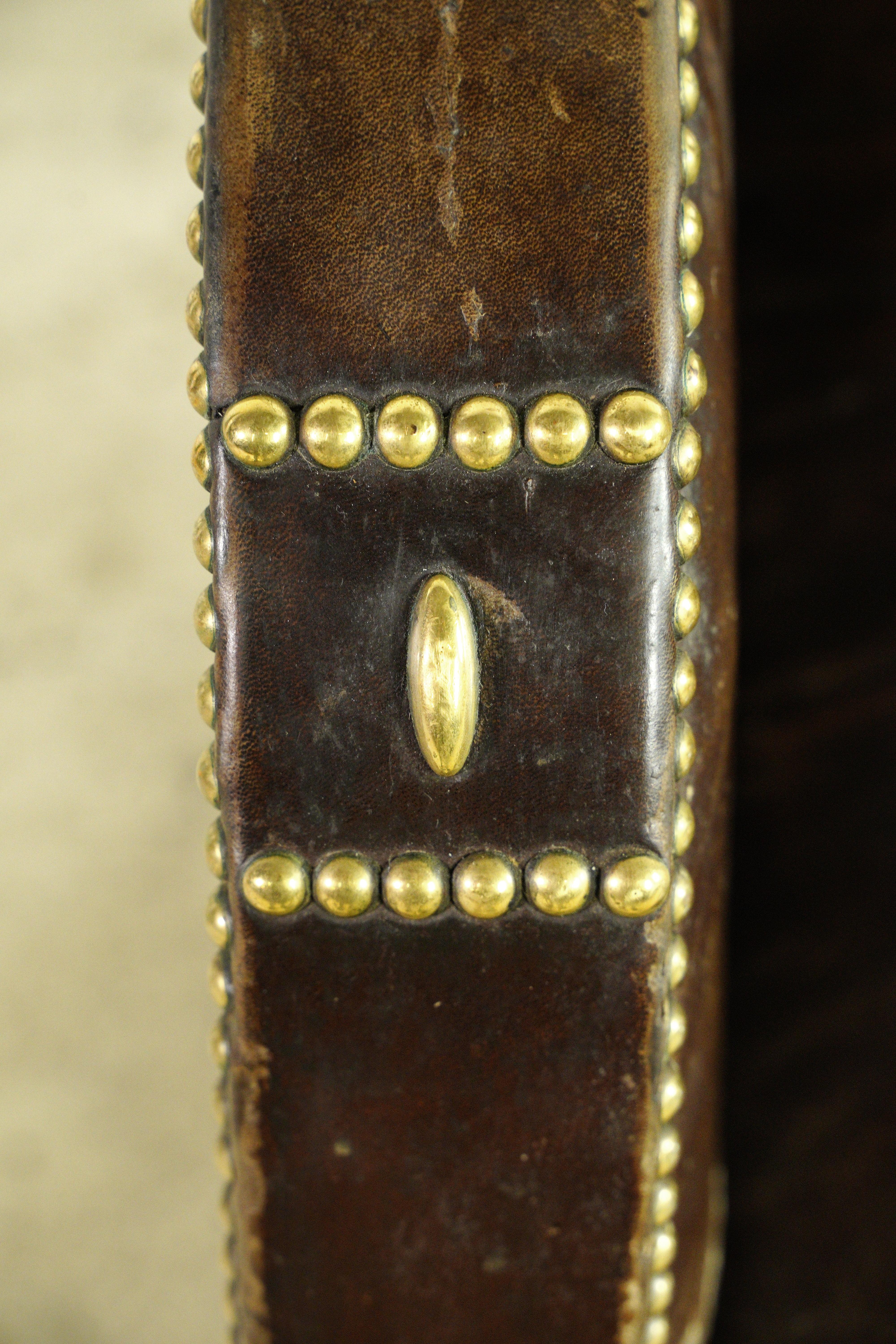 European brass studded brown leather armchair with a cowhide back and wood feet. Good condition with surface wear from age. One available. Please note, this item is located in our Scranton, PA location.