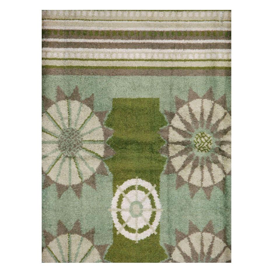 A vintage European Art Deco room size rug inspired by Edward McKnight Kauffer handmade during the early 20th century in green, laurel green, mauve, and cream.

Measures: 7' 11