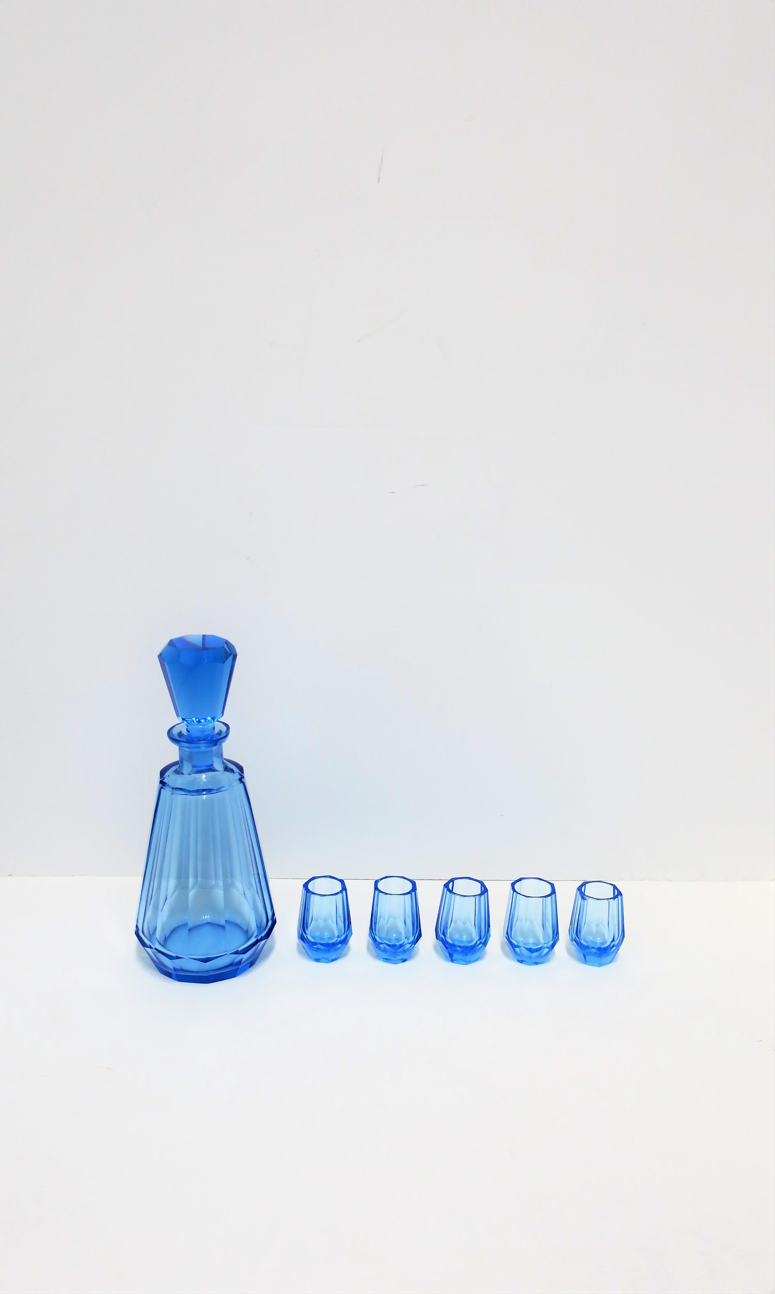 A beautiful European blue crystal liquor or spirits decanter and shot glass set, circa mid-20th century, Europe. Set is attributed to luxury crystal maker Moser. Set includes one decanter and 5 glasses. Decanter top and glasses have a beautiful