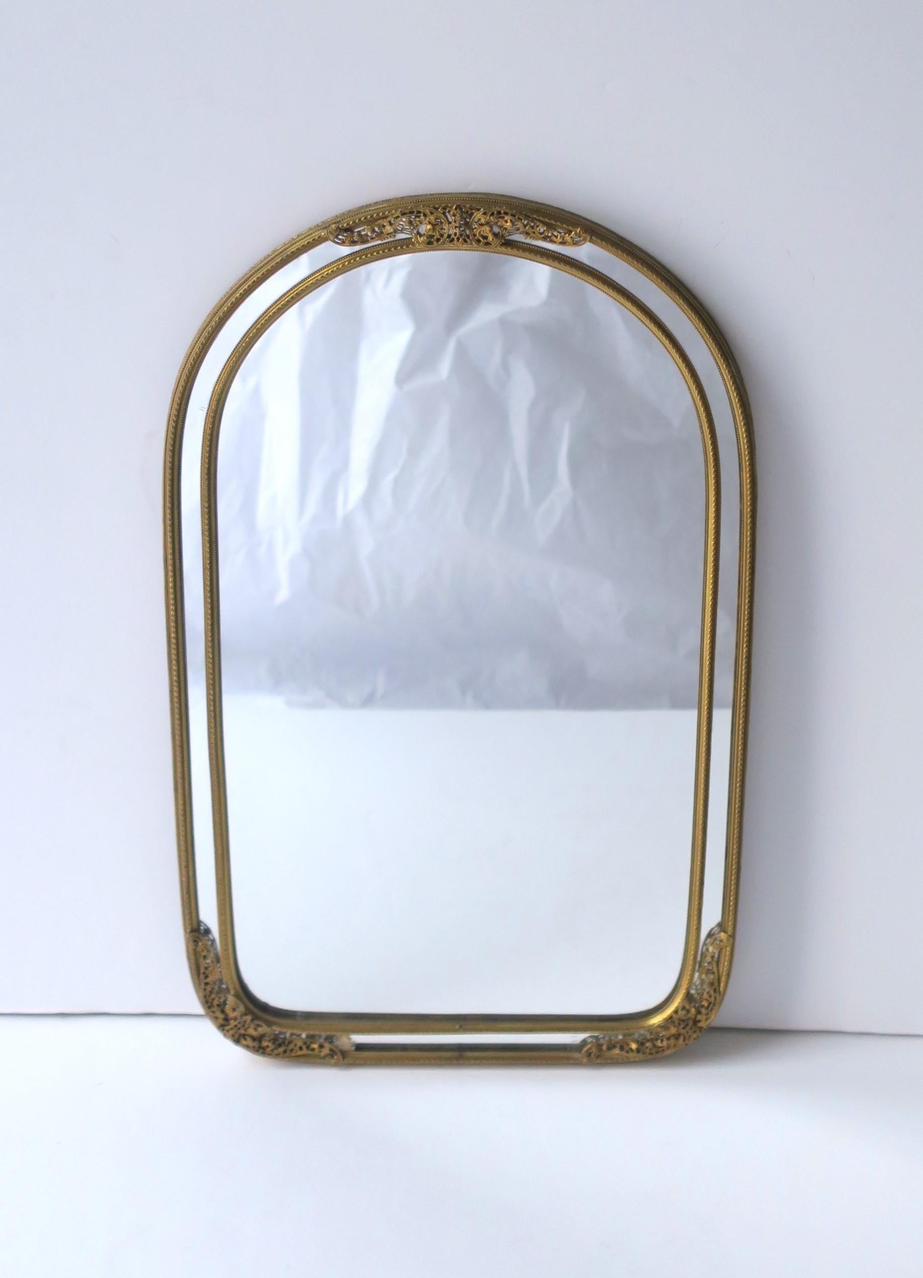 A beautiful and well-made European brass wall mirror, circa early to mid-20th century, Europe. Beautiful, small details are all around this quality brass frame. Mirror is on the smaller side of typical wall mirrors; piece would work well where a