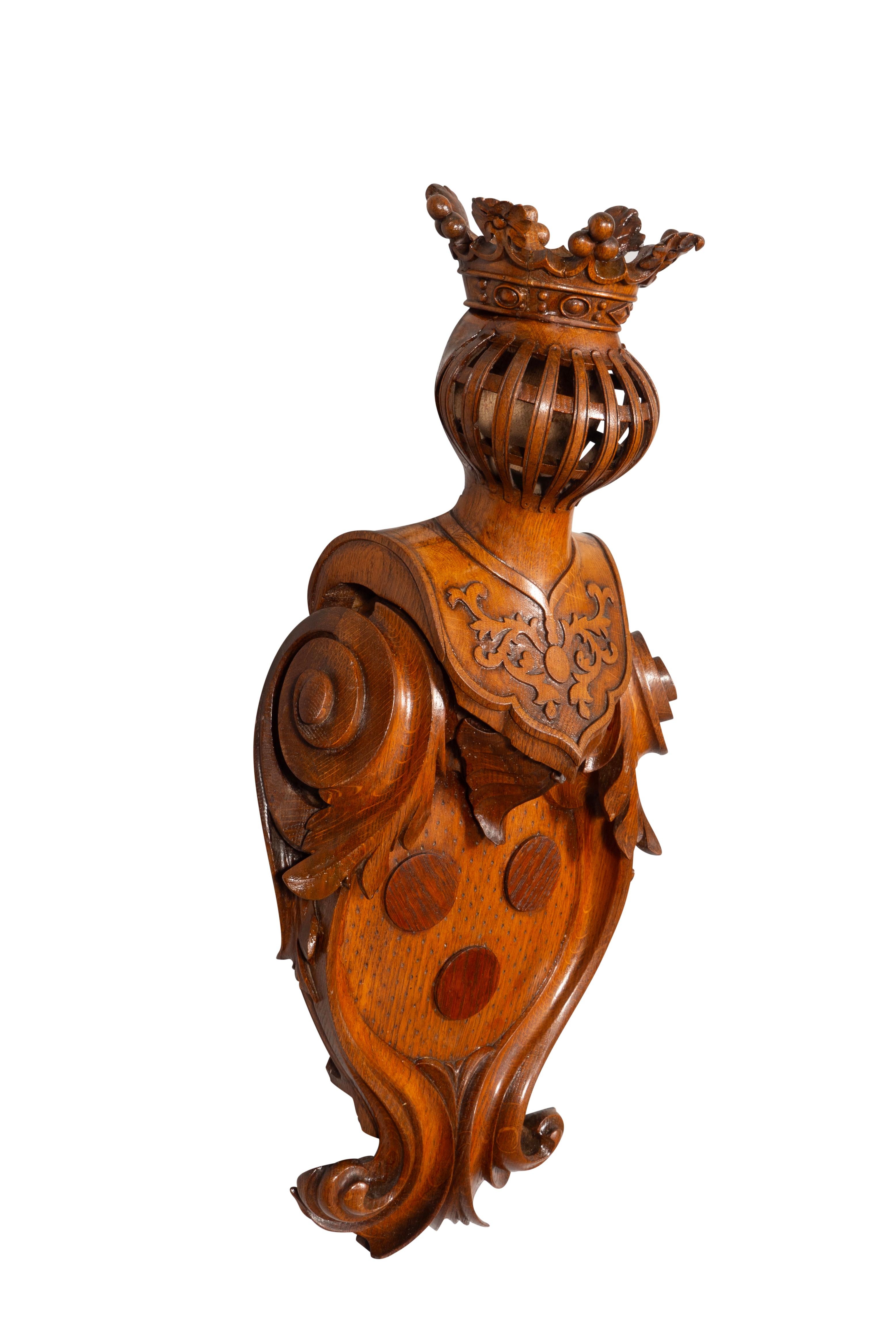 Gut geschnitzte Kartusche mit drei zentralen Rondellen unter einem Turnierhelm und einer Krone.