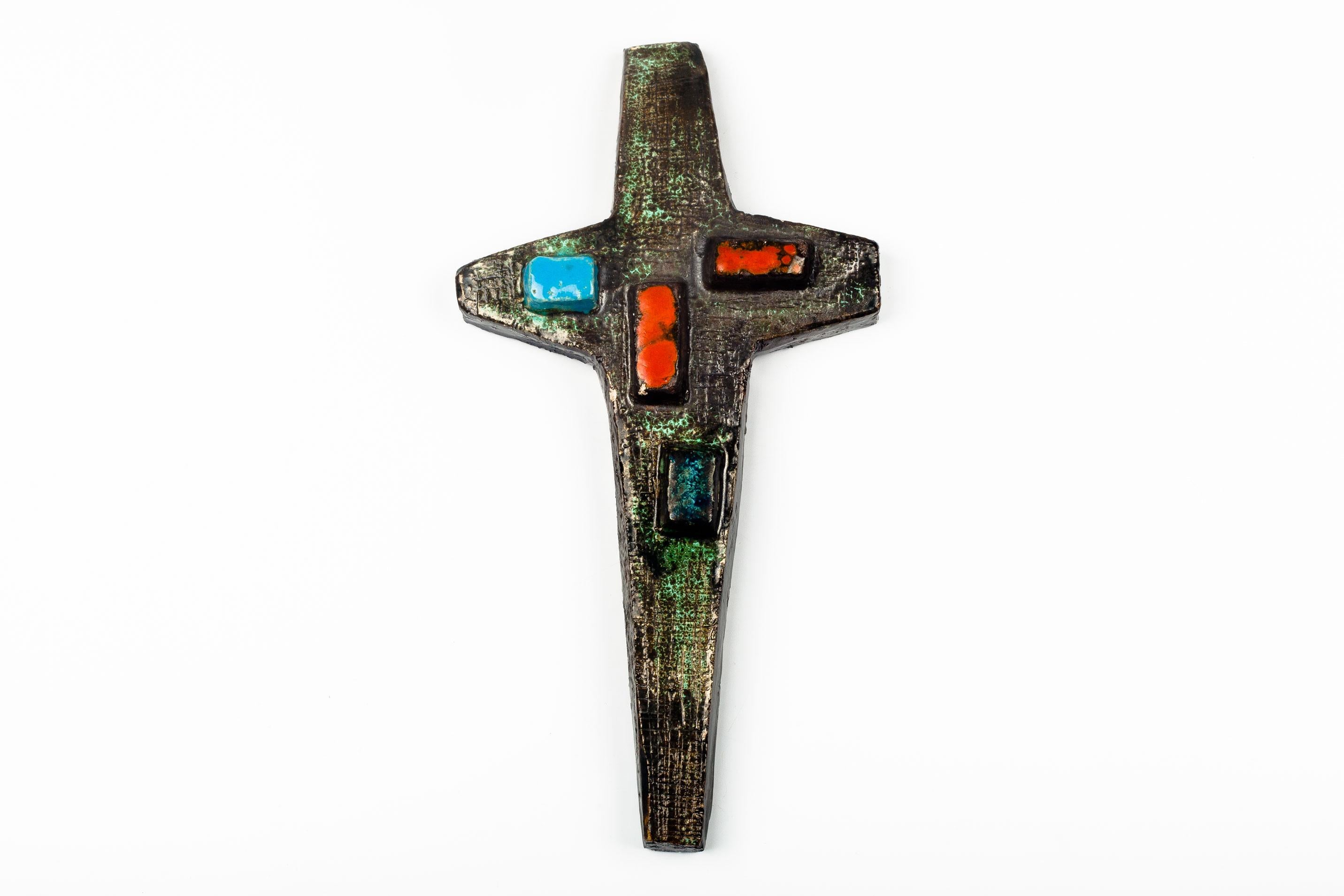 Mid-century European cross in matte, textured and glazed ceramic with red and blue rectangular protrusions. A one-of-a-kind, handcrafted piece that is part of a large collection of European crosses made by artisan potters from the 1950s to 1970s. A