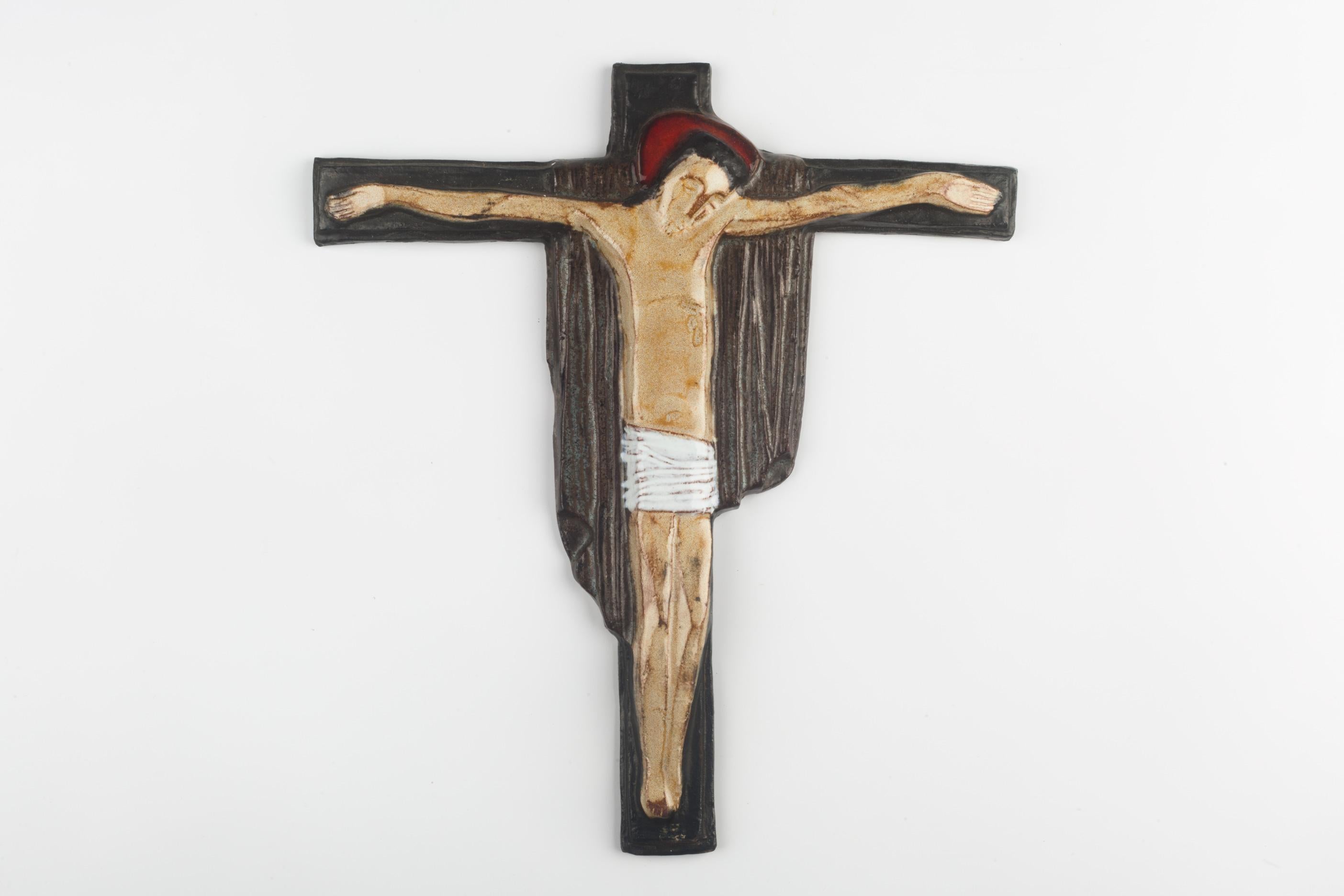 European ceramic wall crucifix in brown, red and white, with christ figure realized in soft volumes. A one-of-a-kind, handcrafted piece that is part of a large collection of European crosses made by artisan potters from the 1950s to 1970s. A unique