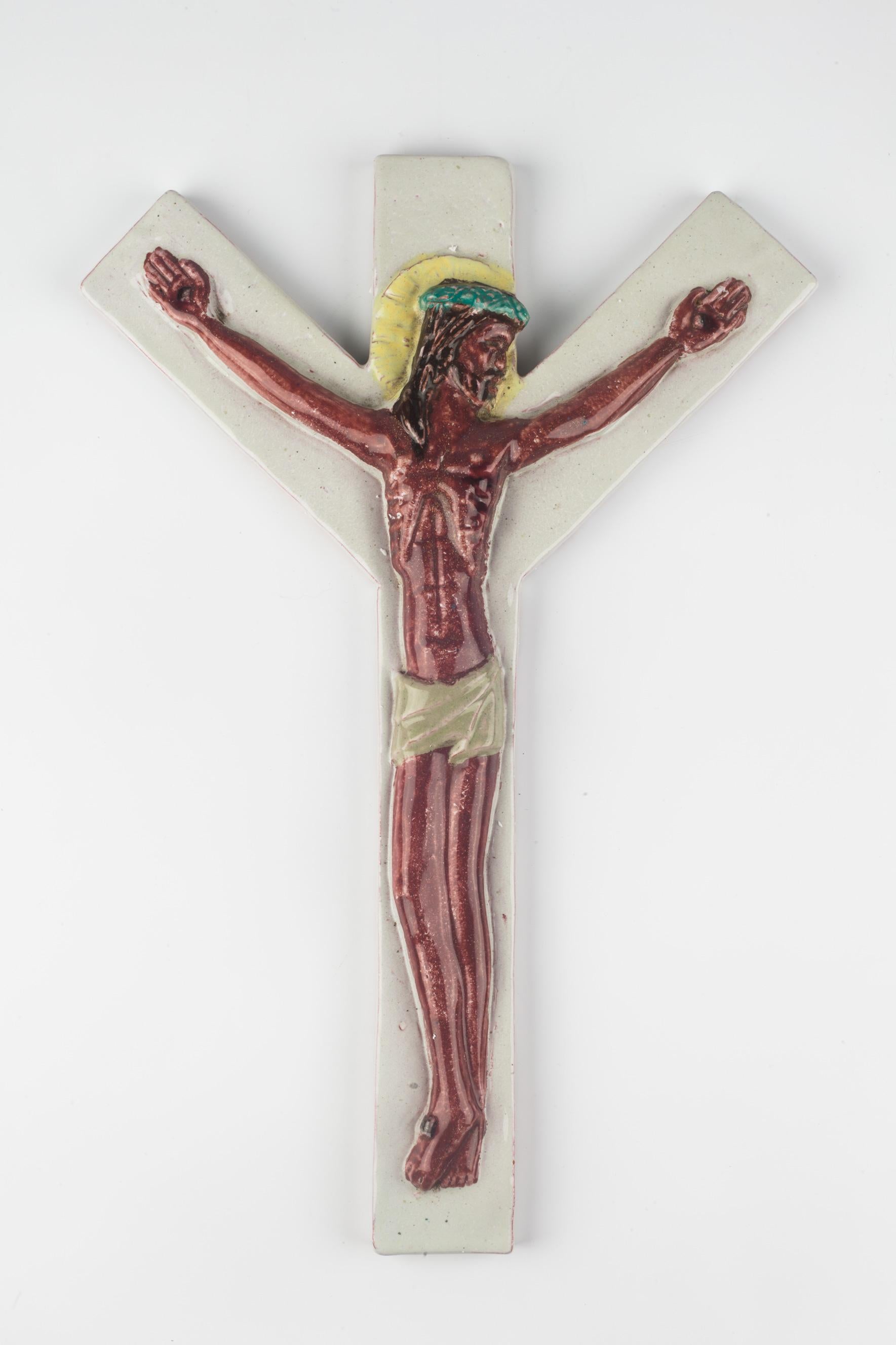 Large ceramic crucifix, over thirteen inches tall, handmade in Europe in the 1970s. Colorfully hand-painted in brown, yellow, turquoise and white, with a highly detailed figurative Christ. A one-of-a-kind, handcrafted piece that is part of a large