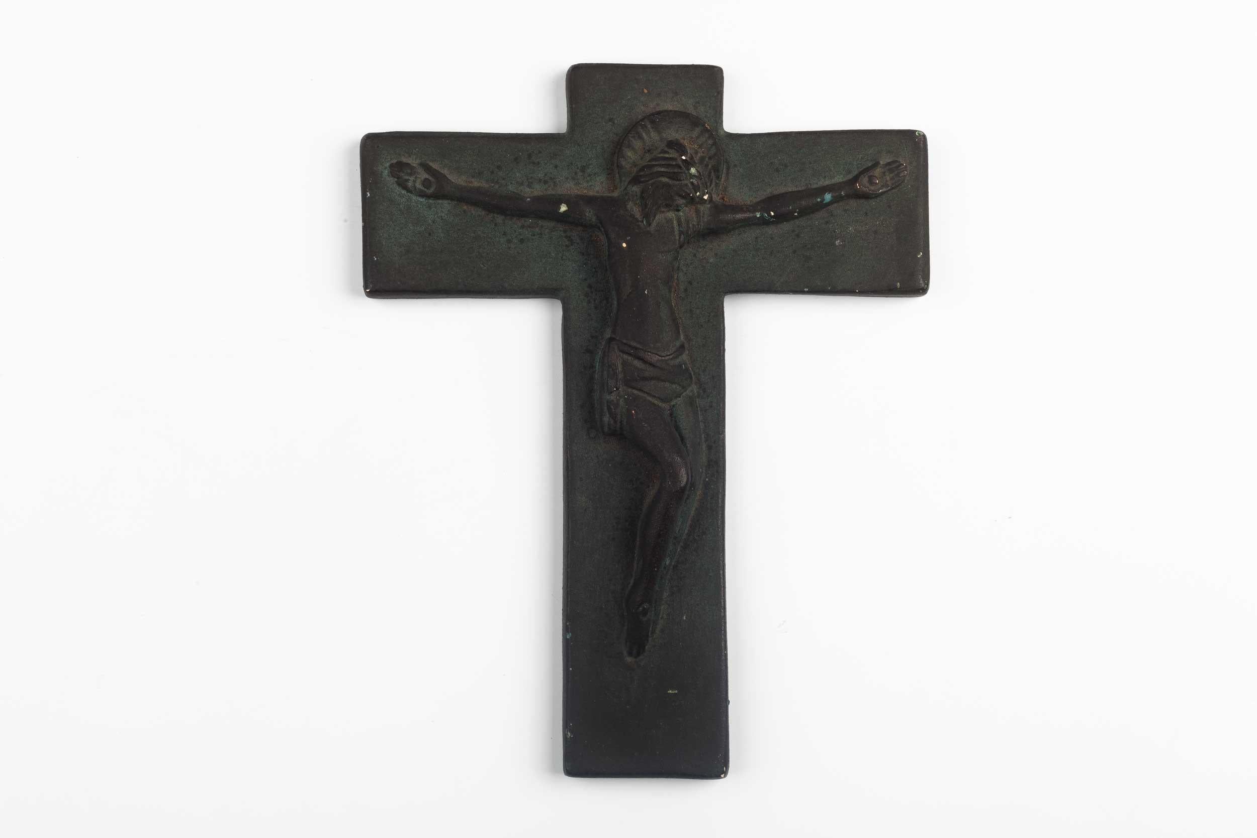 Matte, charcoal colored mid-century European ceramic crucifix with angelic swathed christ figure in volume. Patina small flea bites throughout. A one-of-a-kind, handcrafted piece that is part of a large collection of crosses made by artisan potters