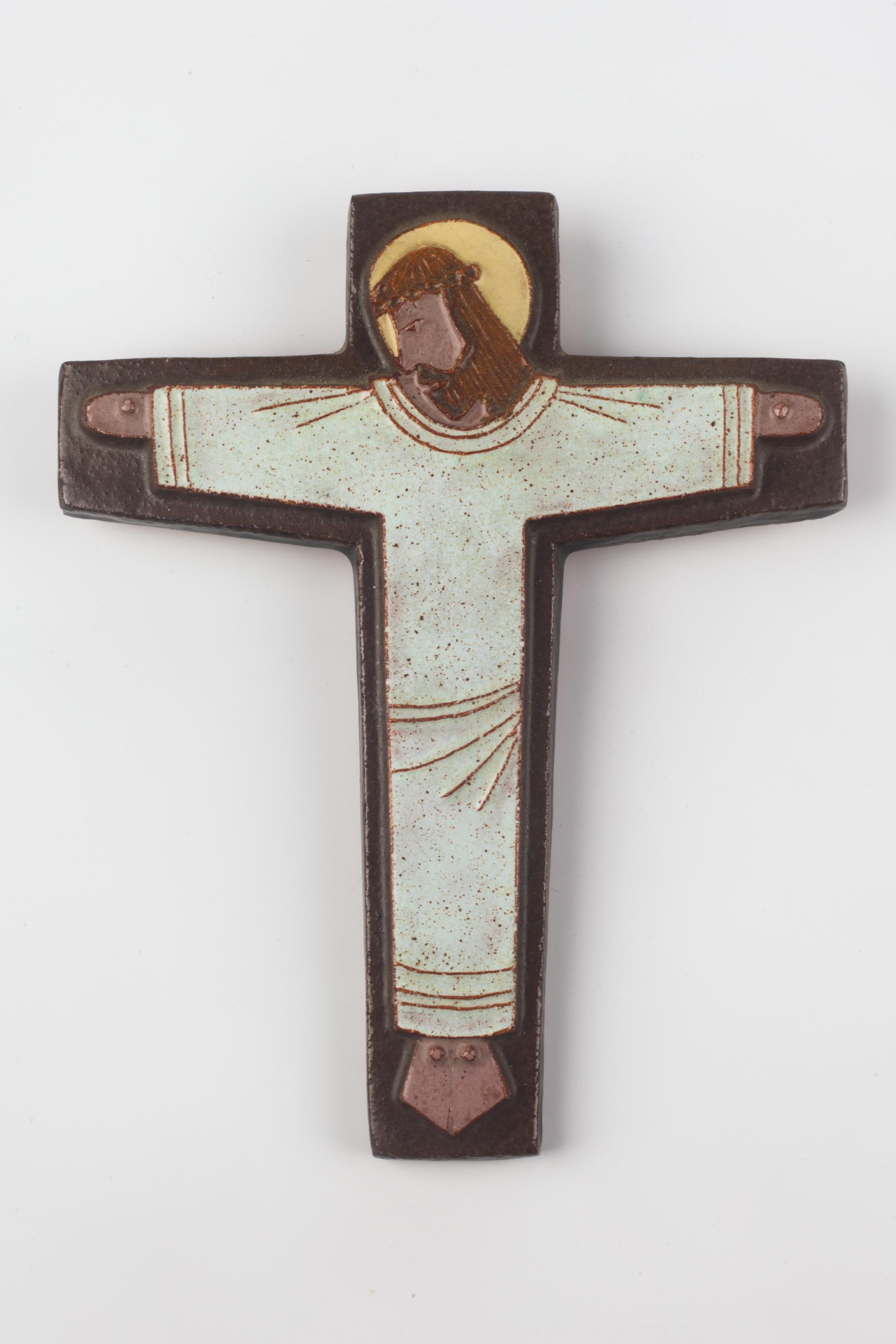 Ceramic European crucifix in glazed red-brown and burgundy with yellow, white, and brown raised Christ figure at its center. A one-of-a-kind, handcrafted piece that is part of a large collection of crosses made by artisan potters from the 1950s to