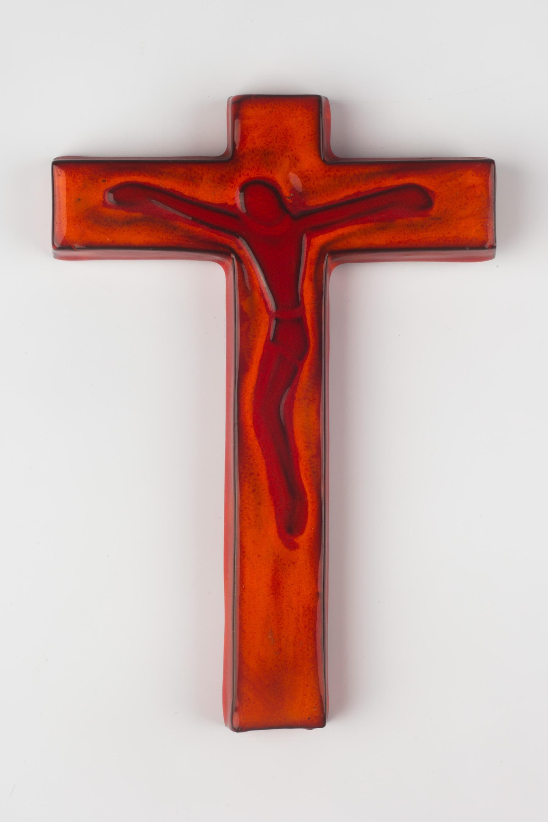 Ceramic, mid-century European crucifix. Hand-painted and glazed in bright and dark orange with black contours outlining the Christ figure and cross. The shape of the figure is surprisingly reminiscent of Keith Haring's iconic works, and with