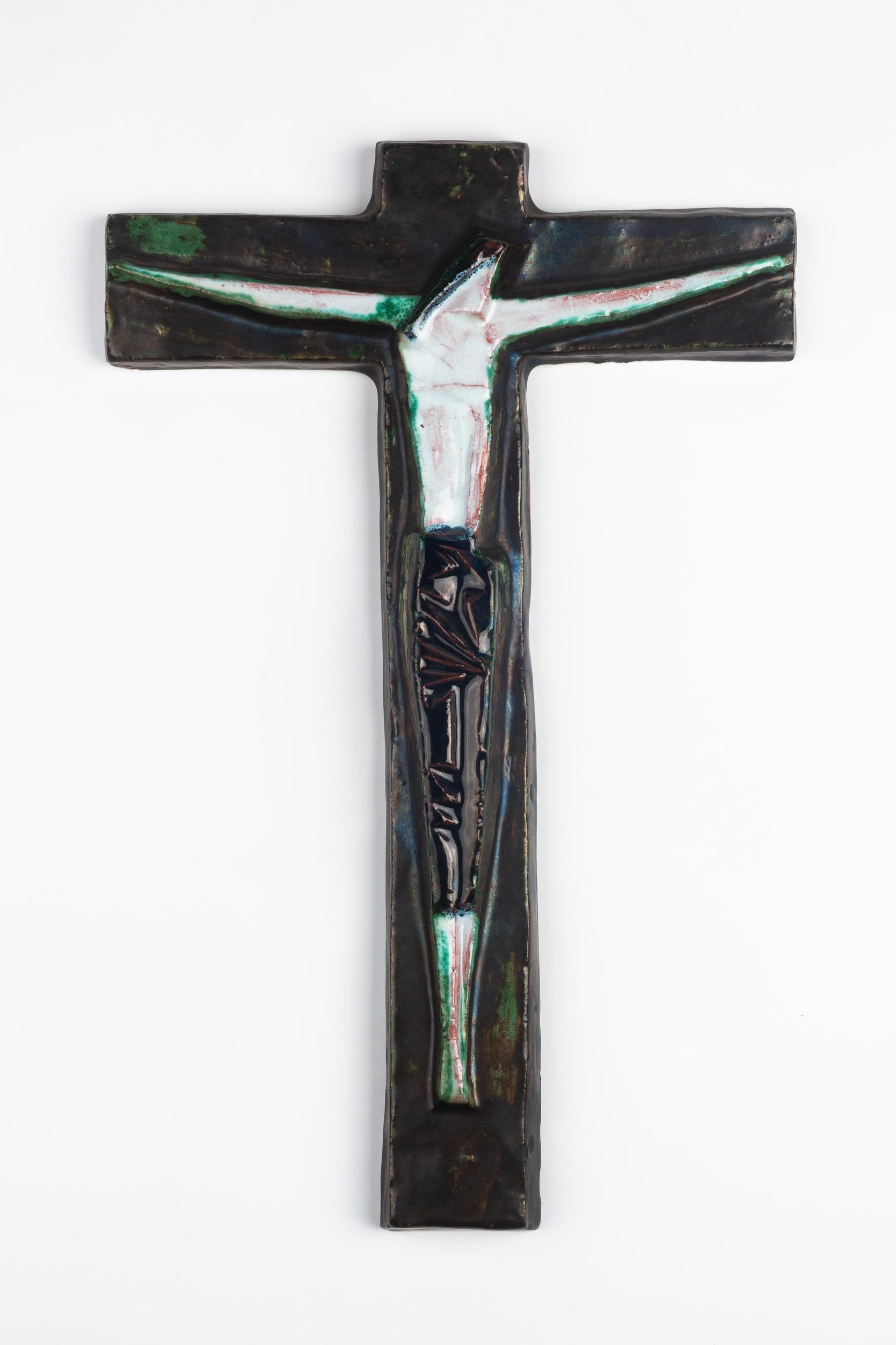 Belgian wall cross in ceramic, hand painted in matte black with blues and greens on an abstracted Christ figure.

From modernism to brutalism, the crosses in our collection range from being as Futurist as a modernist church to as raw as a