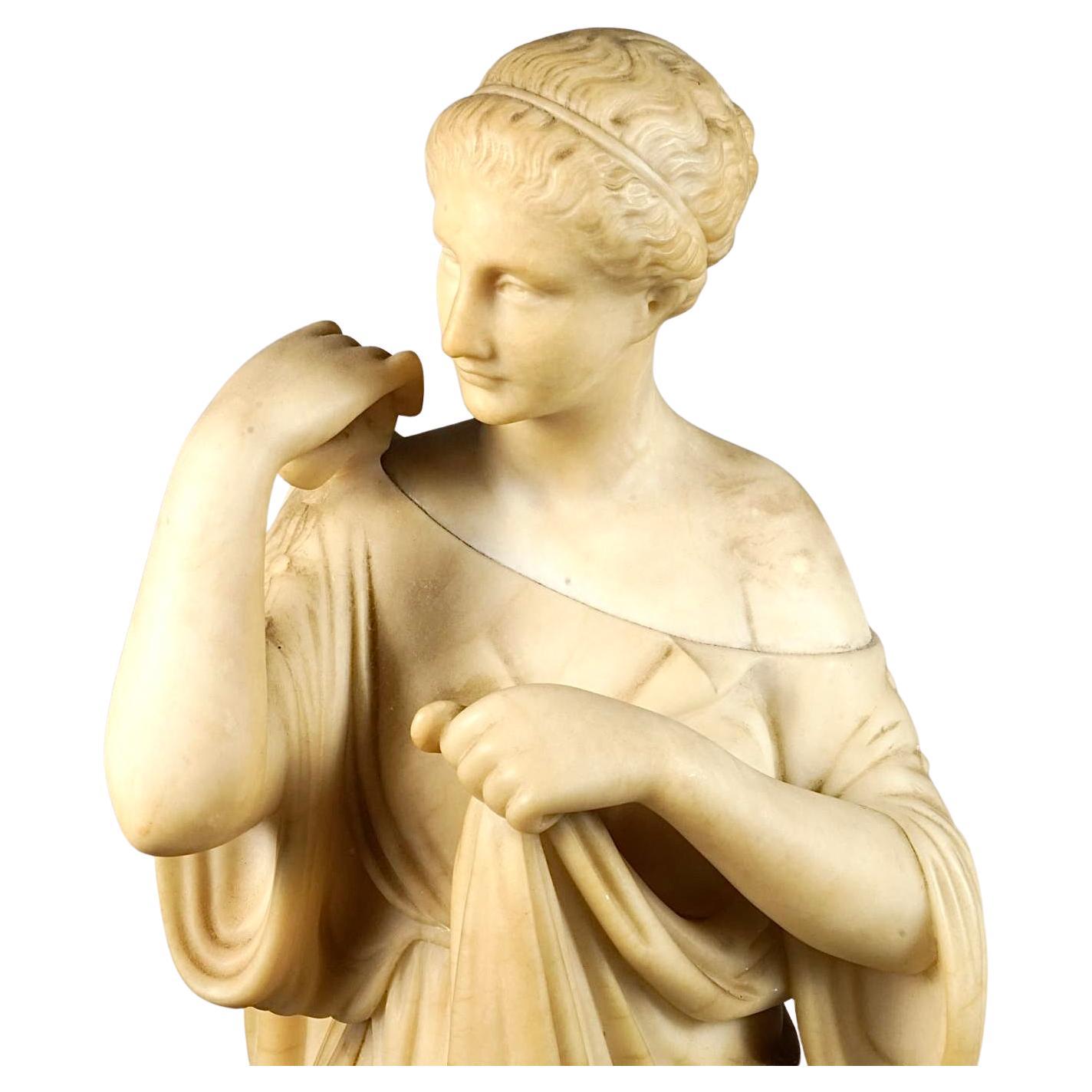 19th Century European Classical Alabaster Figure of Diana, a reinterpretation of the ancient Roman statue. This statue known for its graceful portrayal of th goddess Diana, depicts her in a standing pose, with her body slightly turned, conveying a