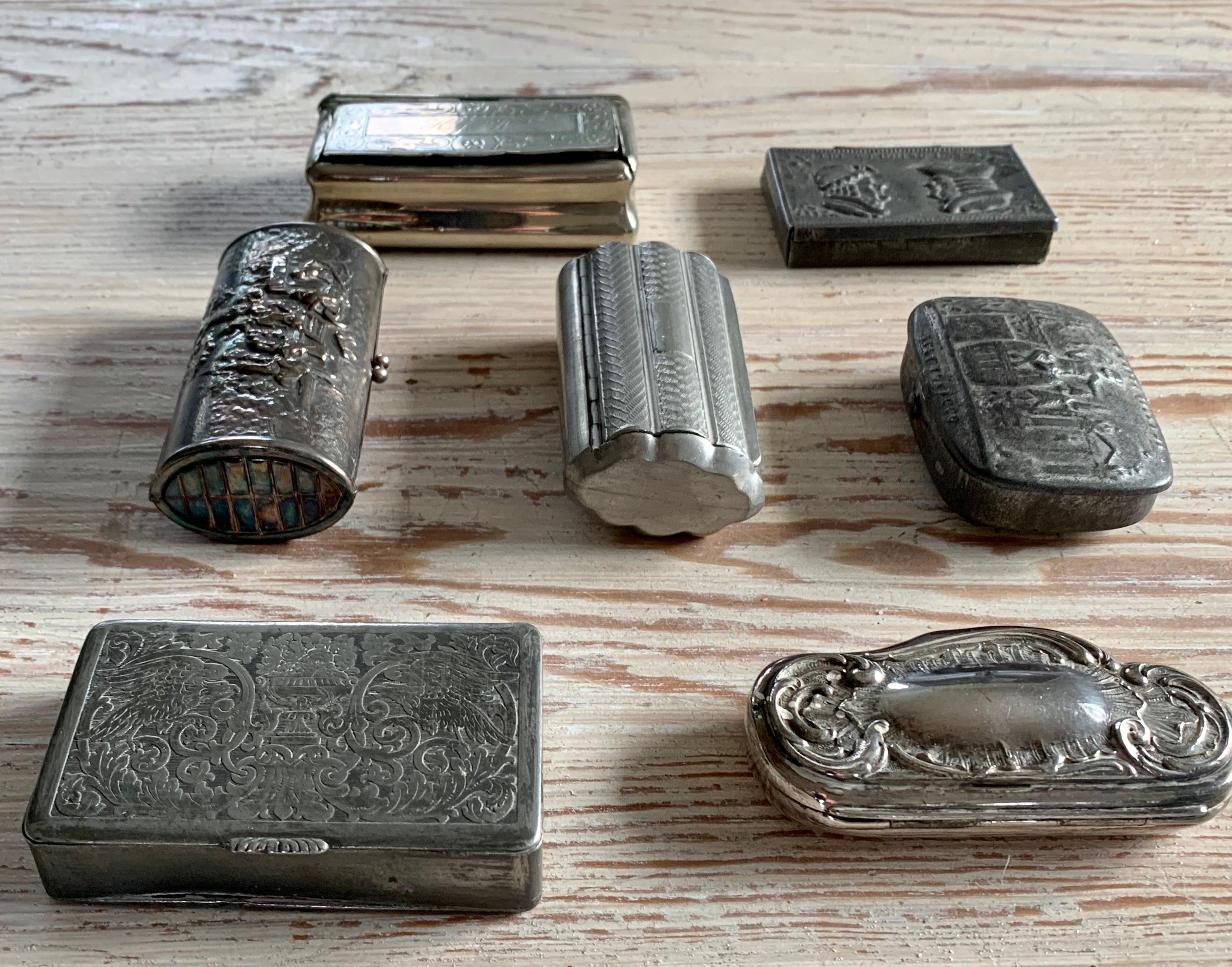 A curated collection of seven small antique boxes in variation of different metals.
The collection includes: 
- One pewter box illustrating a double faced married couple including the text 