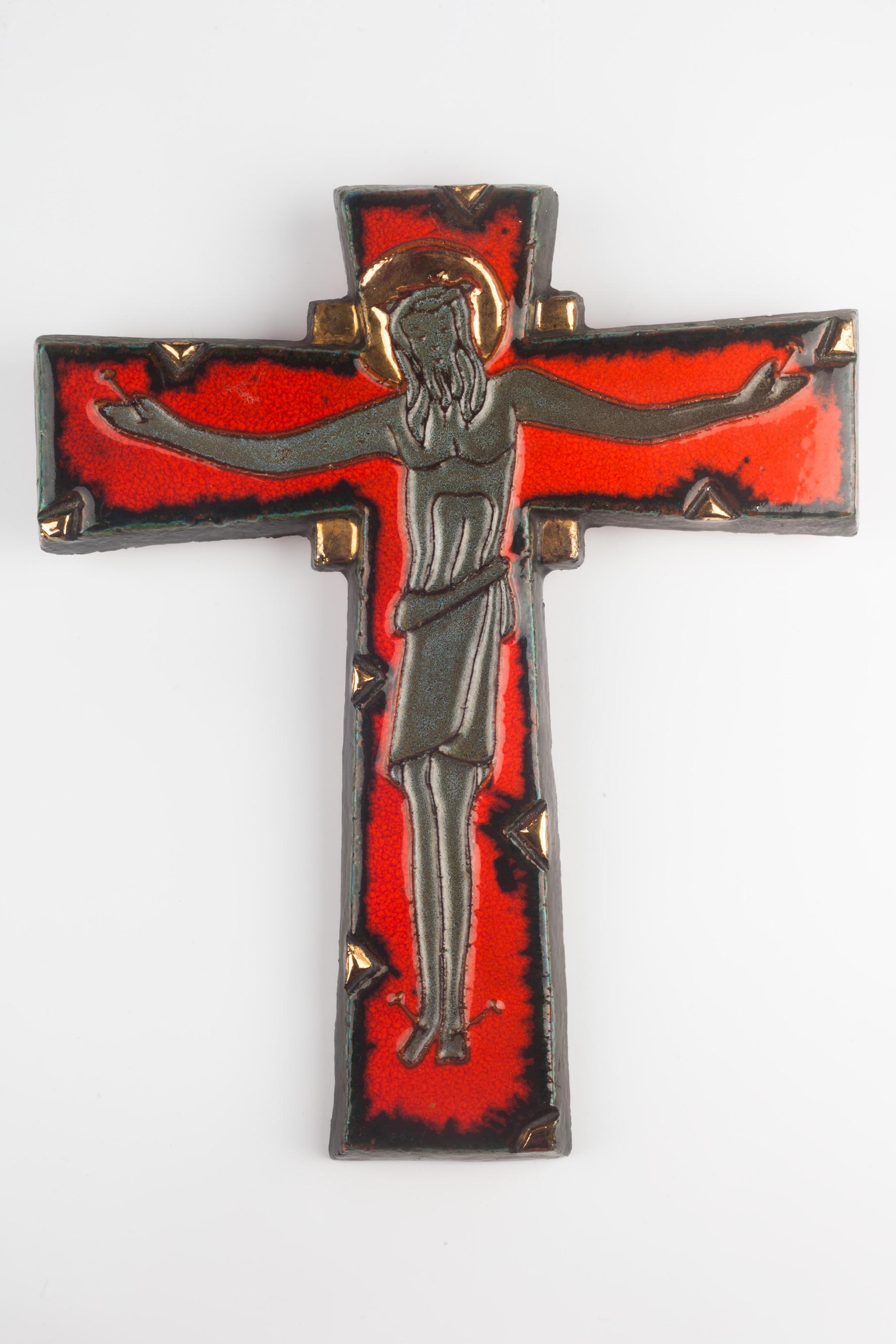 Massive ceramic crucifix in red, black and grey with gilt accents, made in the 1970s. Embossed Christ figure with soft features. A one-of-a-kind, handcrafted piece that is part of a large collection of crosses made by artisan potters from the 1950s